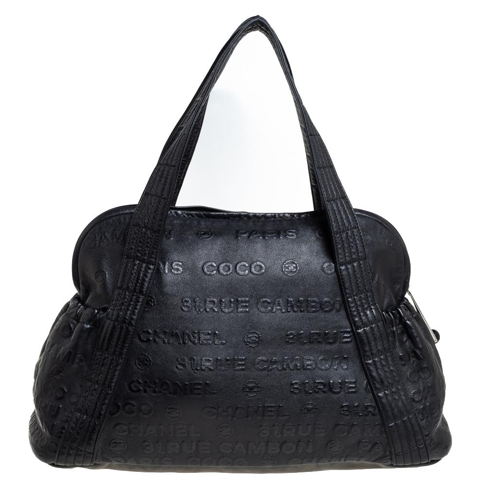 Mit dieser Schultertasche setzt Chanel seine Tradition der begehrten Taschen fort. Die in Italien gefertigte Tasche besteht aus schwarzem Leder und trägt die Prägungen Chanel CC 31 Rue Cambon Paris:: Coco und Chanel. Die Tasche ist mit zwei Griffen