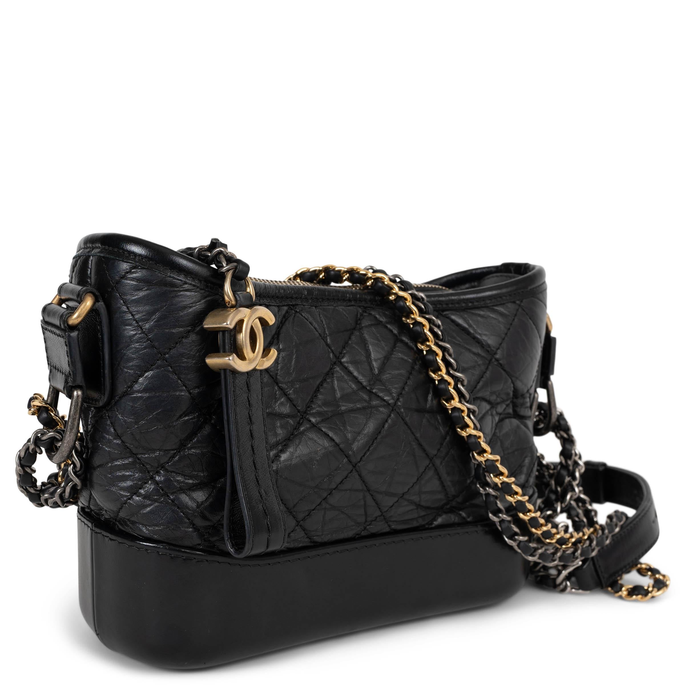 This 100% authentic Chanel Gabrielle Small Hobo bag is crafted in black quilted Aged Calfskin leather with a smooth leather base, offering a rich textural contrast. It features a versatile crossbody chain strap woven with gold-tone, silver-tone, and