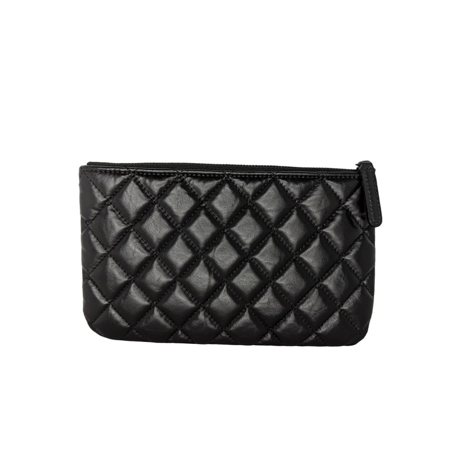 Chanel Aged Calfskin Quilted Medium Reissue Cosmetic Case So in Black. This stylish cosmetic pouch is crafted of diamond-quilted leather in black with a small black mademoiselle turn-lock embellishment. The top zipper opens to a black fabric