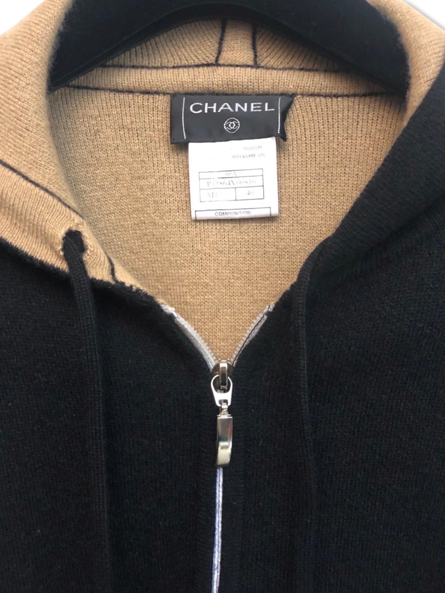 - This warm and easy to style Chanel bi toned black/camel cashmere long sweater cardigan is good for daily use. It also attaches with a drawstring hoodie. 

- Featuring two front flap pockets. 

- Size 40. 

- 100 % Cashmere. 




