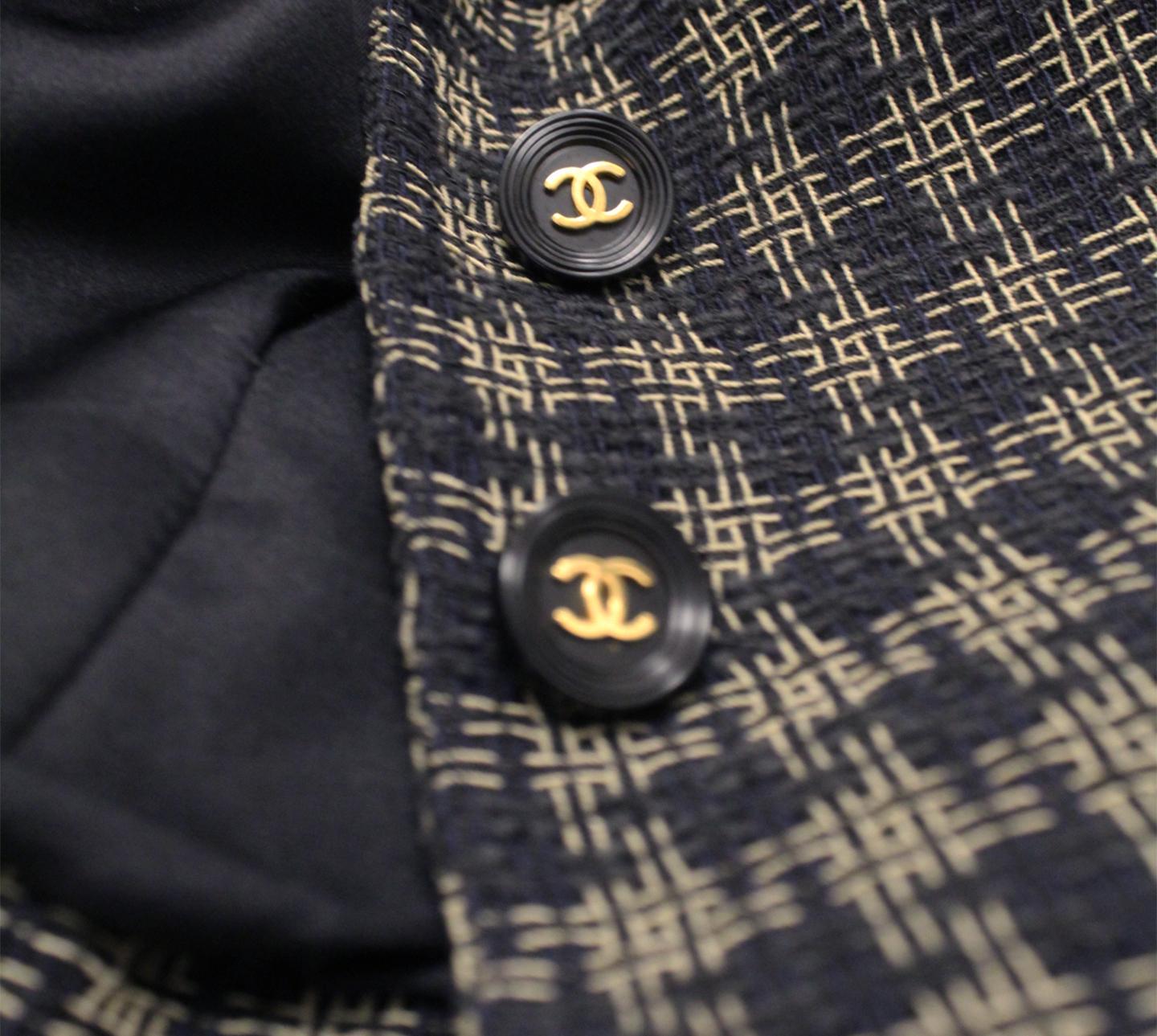 Chanel black and gold tone check cropped jacket with notch collar.  This jacket is accentuated with ornate CC buttons for front closure.  Four front patch pockets decorate this blazer.     With structured shoulders and marked waistline, this cropped
