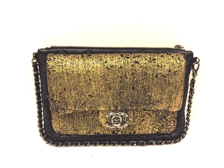 - Chanel black and gold wallet/clutch with leather chain strap from 2012 - 2013 collection. 

- Silver star buckle zip closure. 

- Front “CC” turn lock closure. 

- Measurements: 20cm x 13cm x 4cm. Drop: 18cm
