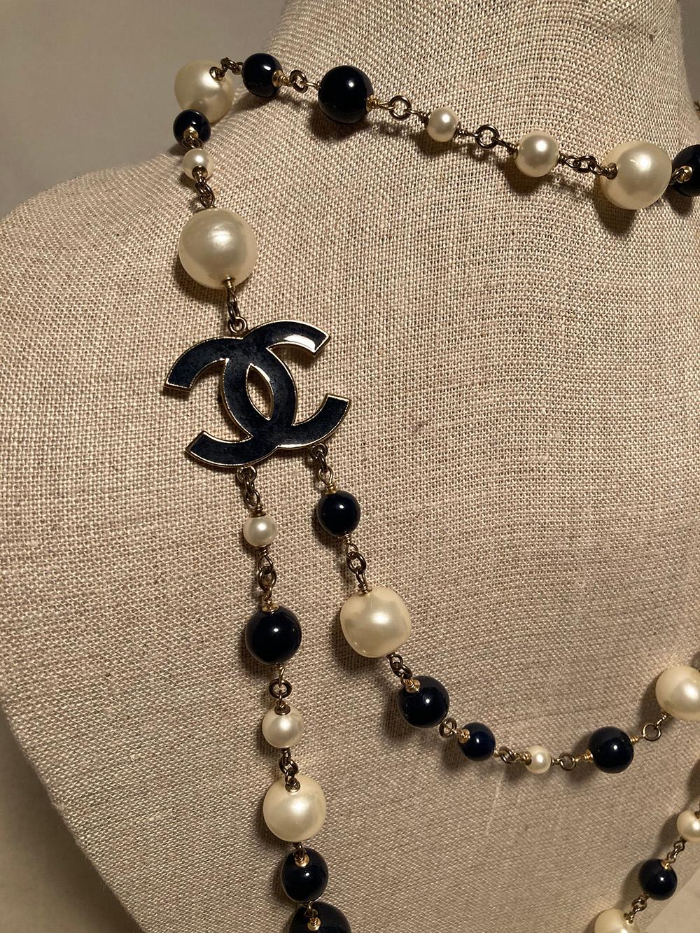 Chanel Black and Pearl Beaded Necklace in excellent condition. Various sized black and pearl beads strung throughout. Black enamel CC logo emblem. Beads measure .25-.75