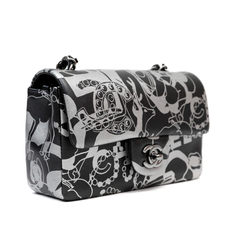 This authentic Chanel Black and Silver Lambskin Mini Classic is in pristine condition.  A limited edition piece from the Cruise Collection, it is a lovely addition to any collection.  Swirling abstract print in black and silver lambskin with silver