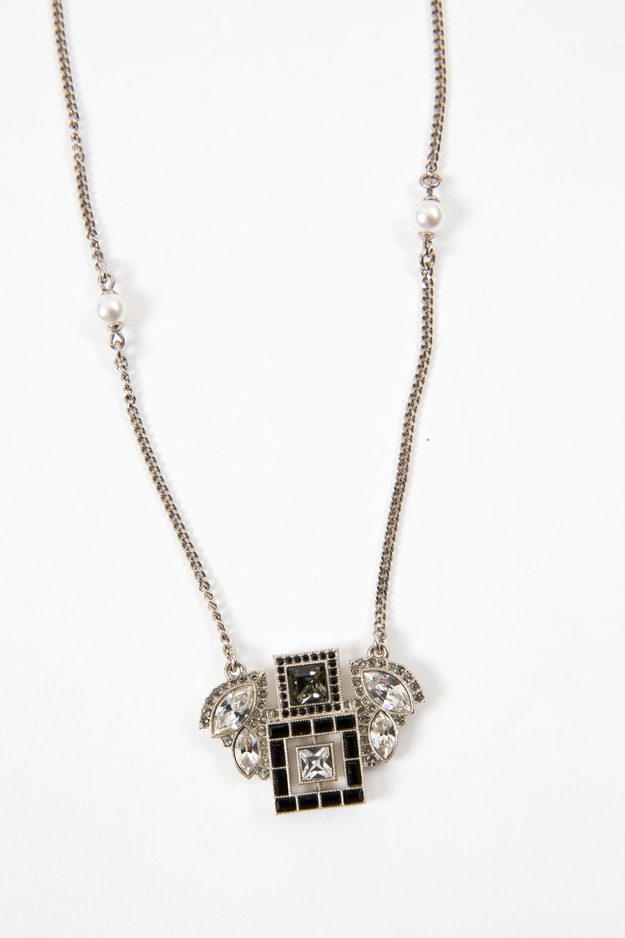 Chanel black and silver-tone chain embellished necklace featuring a silver-tone chain, black and silver crystal embellished with mini signature interlocking CC logo, fancy and faux-pearls on a silver-tone chain, a lobster claw fastening logo pitted