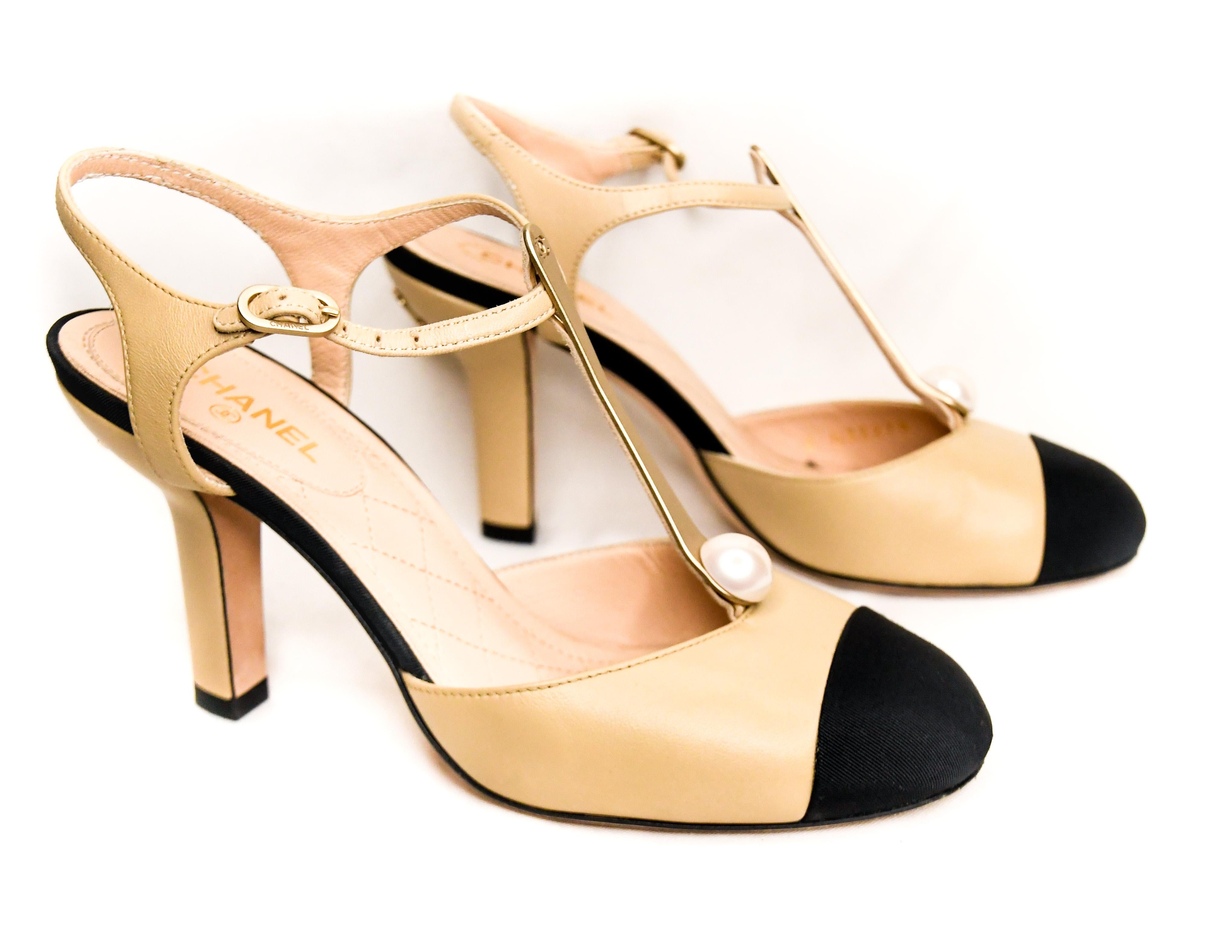 Classic Chanel T Strap shoes are worthy of Coco herself!  Features included signature tan leather and black grosgrain capped toes, sculpted heels  and matte gold tone hardware.  Adjustable ankle straps.  Leather padded insoles and soles.  Pearls at