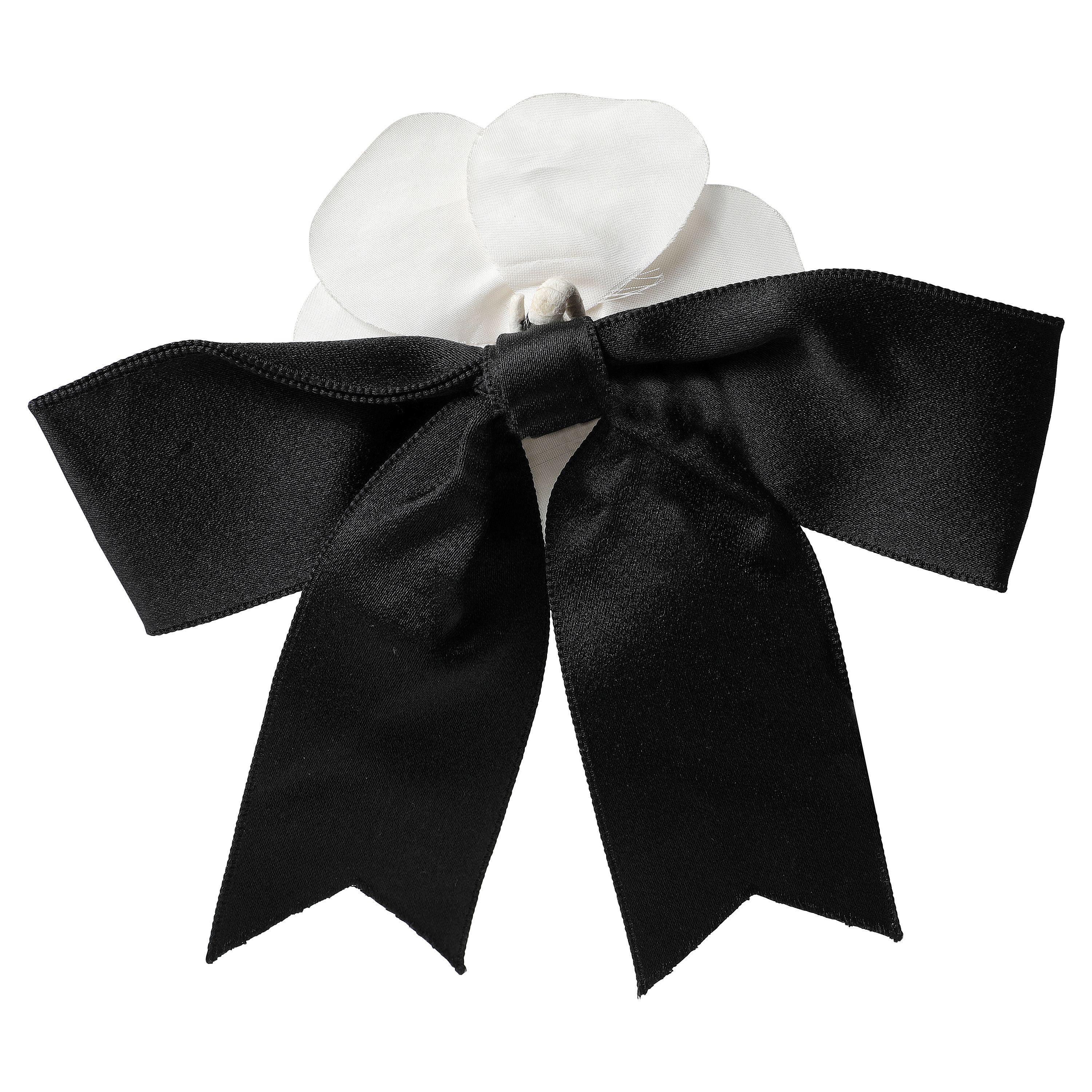This authentic Chanel Black and White Camelia Bow Pin is pristine. Large black silk bow with white camellia flower.  

PBF 13002
