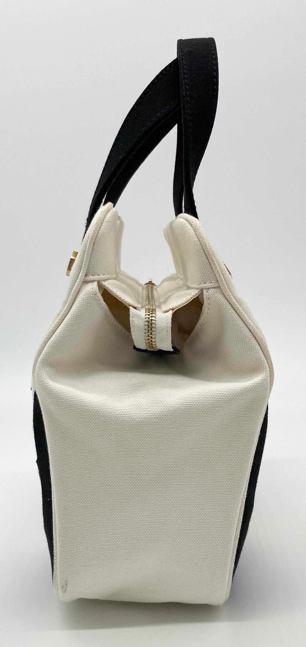 Chanel Black and White Canvas Marshmallow Bag in very good condition. Black and white canvas exterior with top zipper closure and double black canvas handles. White nylon interior with one zip pocket. Light tiny small spots of discoloration