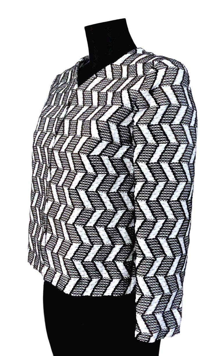 New pre-owned jacket from the house of Chanel crafted in a black and white geometric pattern cotton tweed.
It features dramatic design CC logo embossed silver tone half hidden hook back button closure at cuffs.
It has a collarless V-neck line and