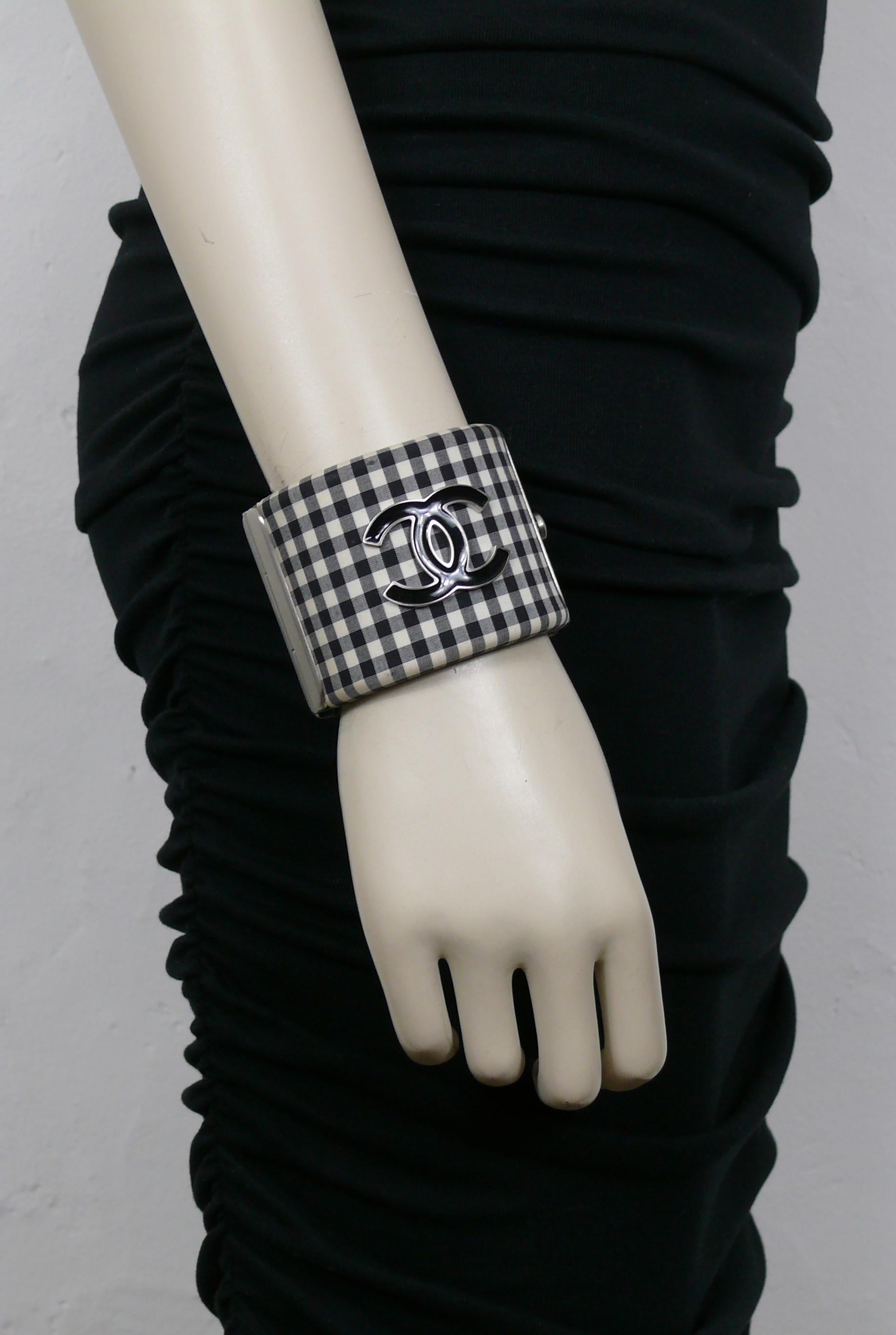 CHANEL by KARL LAGERFELD black and white gingham / vichy print cuff bracelet featuring a silver tone metal and black enamel CC logo at the center.

From the Resort Collection 2011.

Laser mark CHANEL B11 C MADE IN ITALY.

Indicative measurements :