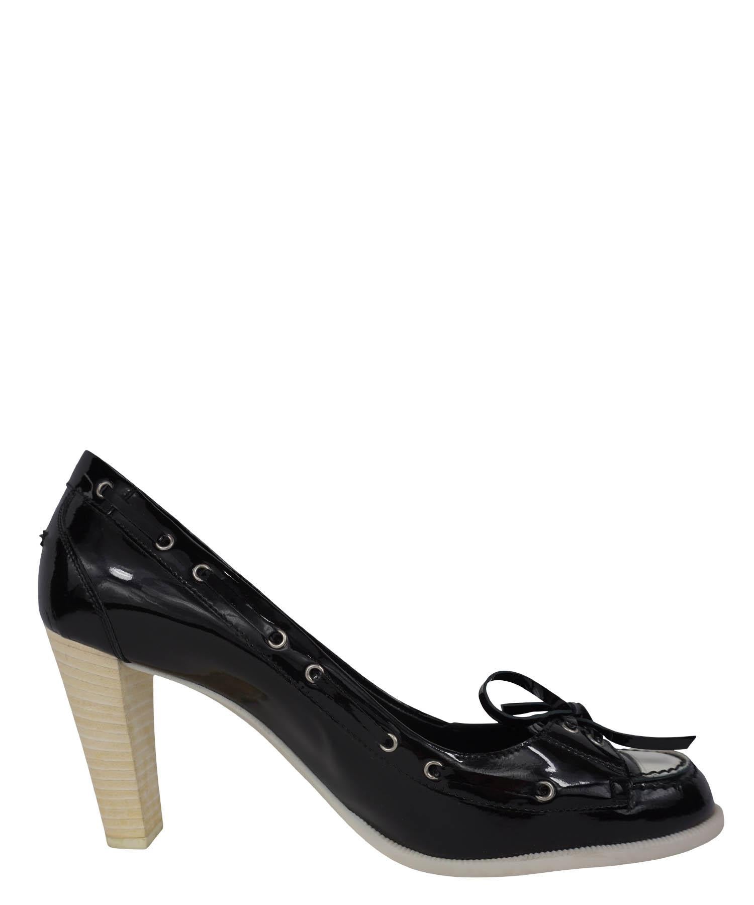 Chanel's unique take on a classic boating shoe dressed up with a high heel. These boat shoe pumps feature high heels, black patent leather with white cap toe uppers, white rubber soles, and laced ties at vamp. Designer size 38. Made in Italy. Minor