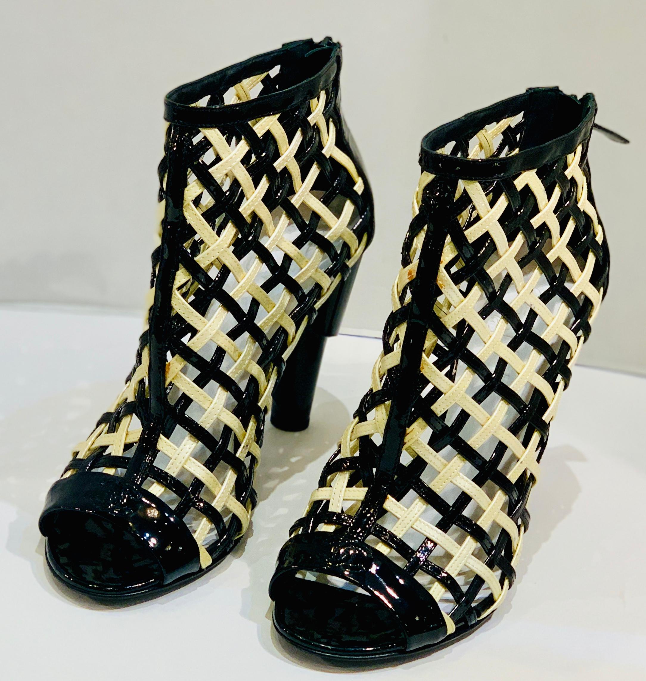 
Hard to find size 11 or 41, Chanel Black and White Patent Leather Cage Peep Toe Booties Shoes from the Spring 2015 runway collection of the legendary luxury brand Chanel. These edgy, ankle high booties feature glossy patent leather in white and