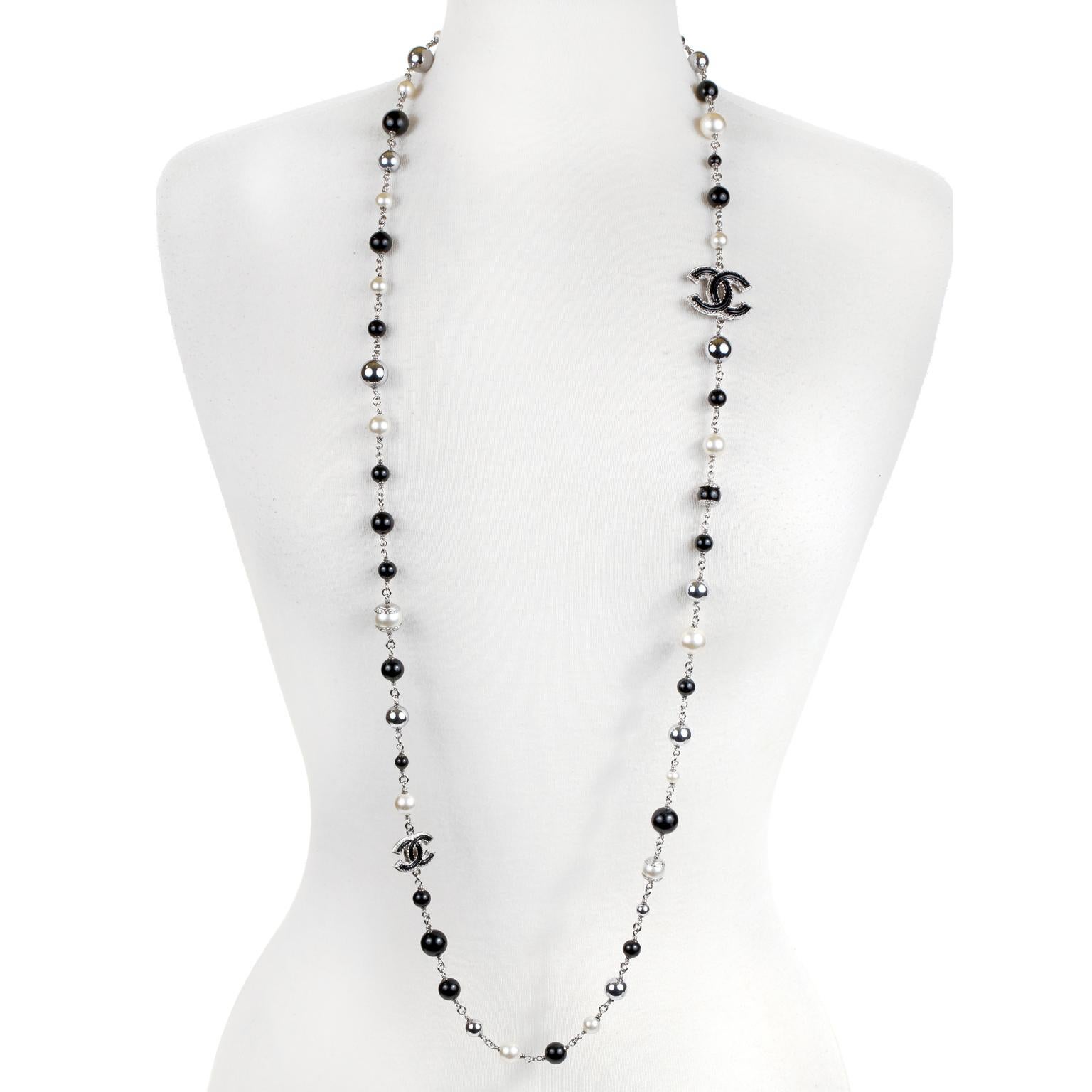 This authentic Chanel Black and White Pearl and Enamel Long Necklace is in excellent condition.  Timeless and versatile, this elegant chain of pearls can be worn with everything from evening wear to T shirts.
Faux pearls, black enamel, and silver