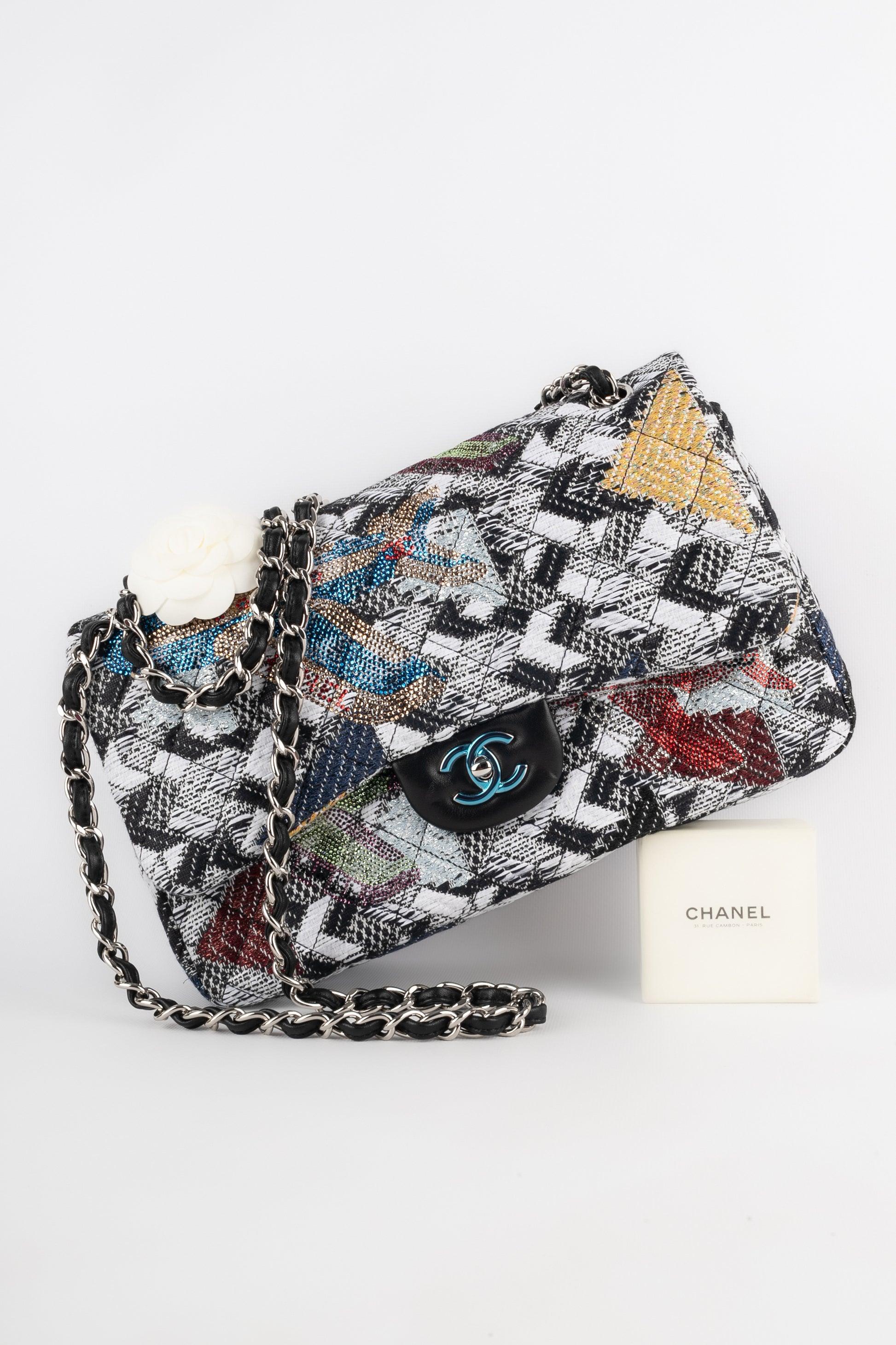 Chanel - (Made in France) 30cm black and white qulted tweed 'Jumbo' bag with stylised chevron patterns, ornamented with rhinestoned patterns and black lamb leather. Silvery metal 'cc' fastener on a double flap. Piece with a Hologramme and a