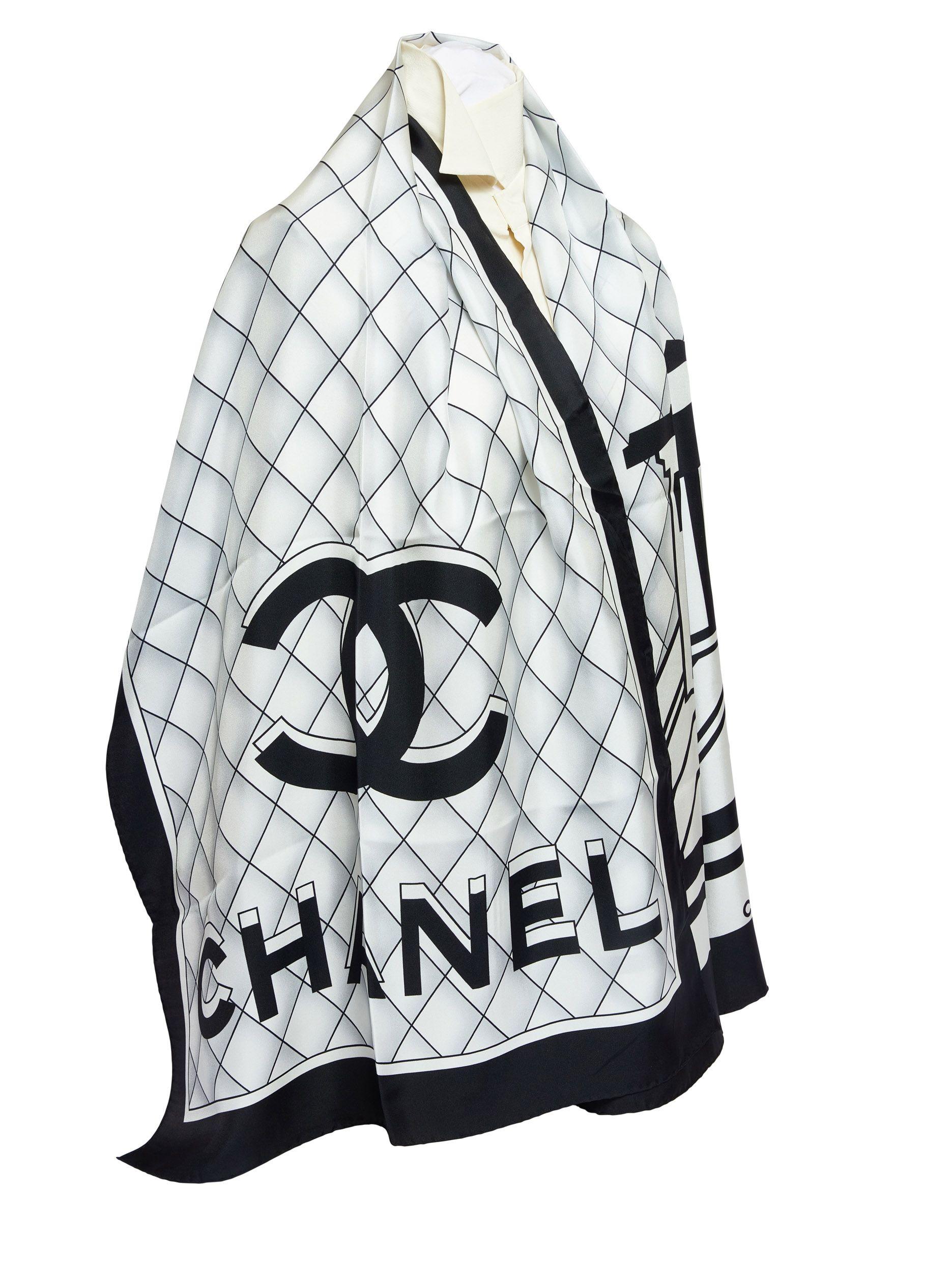 Chanel black and white silk scarf. On the scarf are the Chanel letters printed in 3D. The trim is black and has rolled edges. It is brand new.
