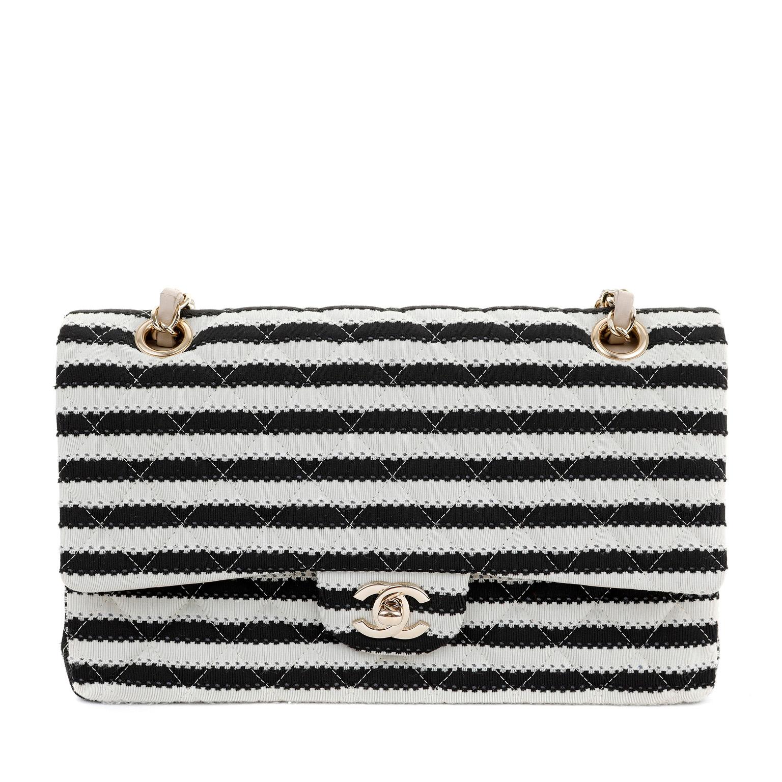 This authentic Chanel Black and White Striped Medium Classic Flap is in very good condition.  Graphic stripes combined with pearl accents makes this a spectacular piece for any collection.

Black and white striped fabric is quilted in signature