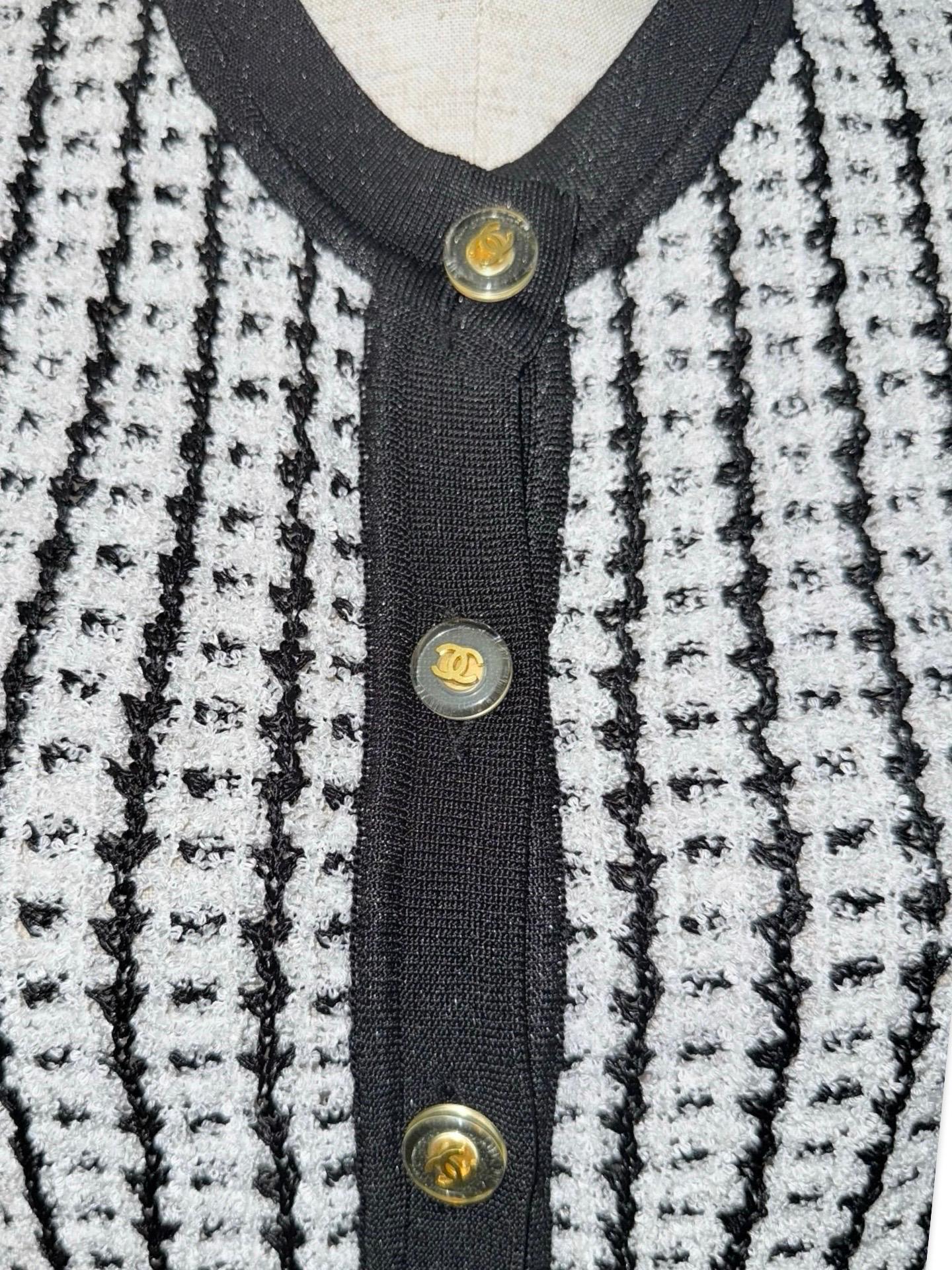 - Iconique tweed noir et blanc de la collection printemps 1997.

- Bordure contrastée.

- Boutons CC gaufrés de couleur or.

- Deux poches à l'avant. 

- Taille 42.

- Mesures : 
D'une épaule à l'autre : environ 15 pouces.
Poitrine : environ 32