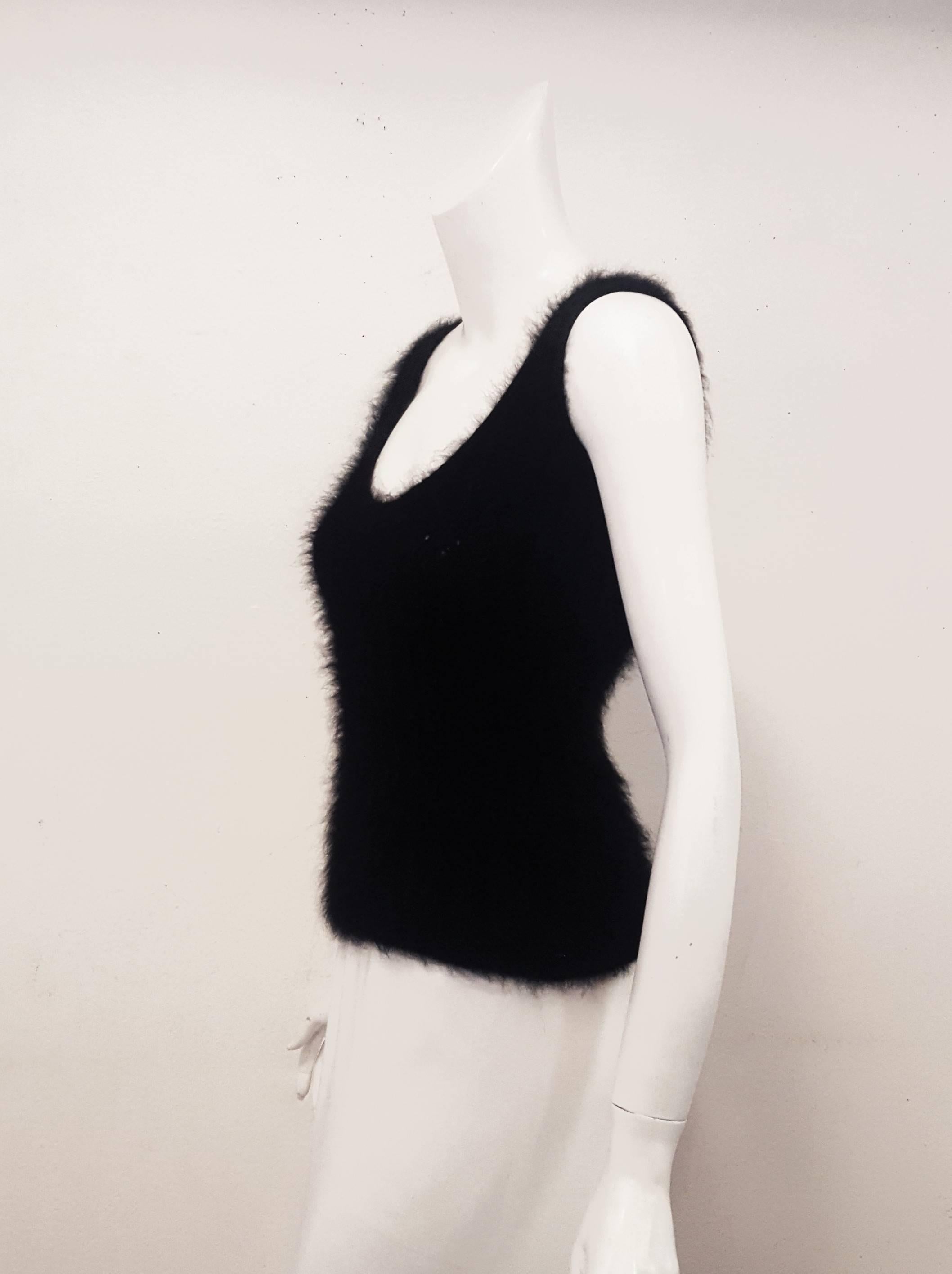 Chanel black angora knit sweater vest that can be worn as a top by itself or with collar shirt as a vest.   Wear it with leggings or a wool skirt for a cozy look.  This V neck sweater has a Chanel CC decoration on the lower left side by the hem. 