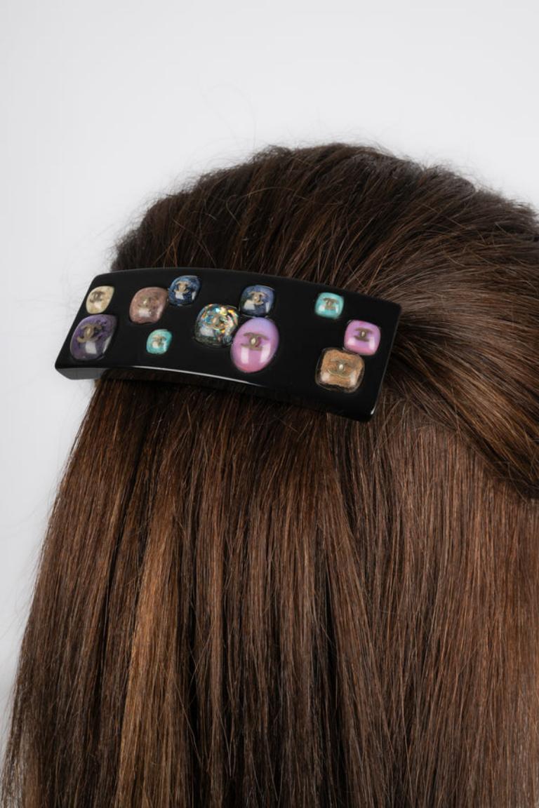 Chanel - (Made in France) Black bakelite hair clip with cabochons inlaying representing hardstones. 2006 Spring-Summer Collection.

Additional information:
Condition: Very good condition
Dimensions: 9.5 cm x 3.5 cm
Period: 21st Century

Seller