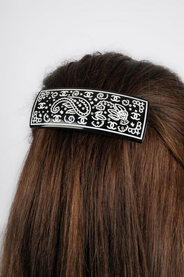 Chanel - (Made in France) Engraved black bakelite hair clip with rhinestones. 2009 Collection.

Additional information:
Condition: Very good condition
Dimensions: 9.5 cm x 3.5 cm
Period: 21st Century

Seller Reference: BARB5
