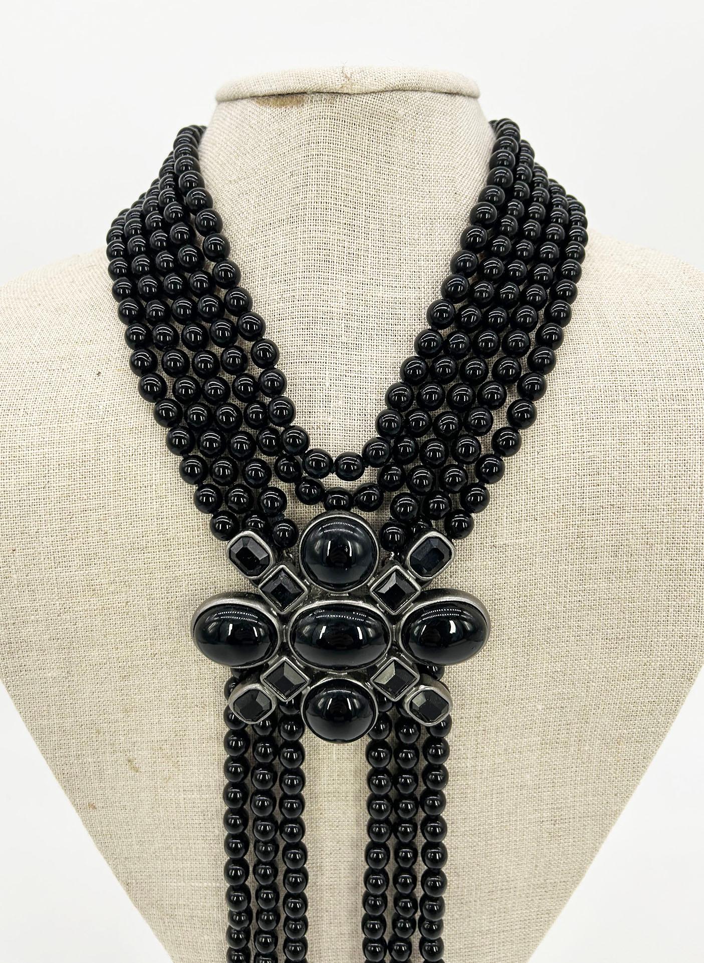 Chanel Black Beaded Multi Strand Emblem Halskette in ausgezeichnetem Zustand. Schwarze Perlen mit silberner Hardware. Schwarze Gripoix-Verzierung in der Mitte. Der obere Teil der Kette besteht aus 5 Reihen von Perlen, während der untere Teil (unter