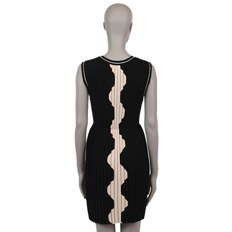 Chanel sleeveless knee-length dress in pleated black wool (100%) with light beige embellishment. Has been worn and is in excellent condition.

Tag Size 36
Size XS
Shoulder Width 40.5cm (15.8in)
Bust 69cm (26.9in) to 100cm (39in)
Waist 60cm (23.4in)