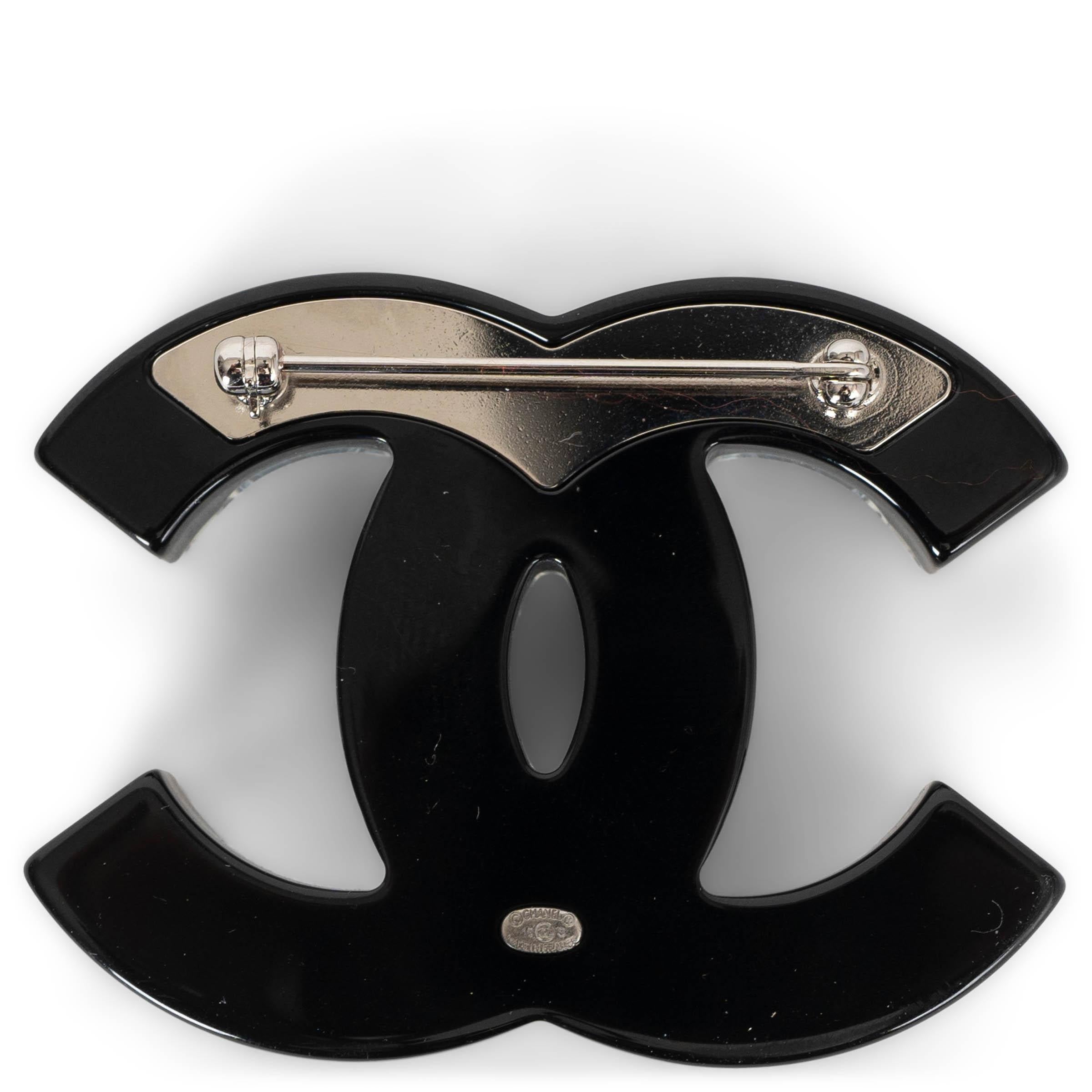 This 100% authentic Chanel 2016 CC Baguette Crystal Brooch is a dazzling accessory, embellished with clear and blue crystals set on a black and clear acetate CC base. A stunning piece from Chanel, it adds a touch of elegance and sparkle to any