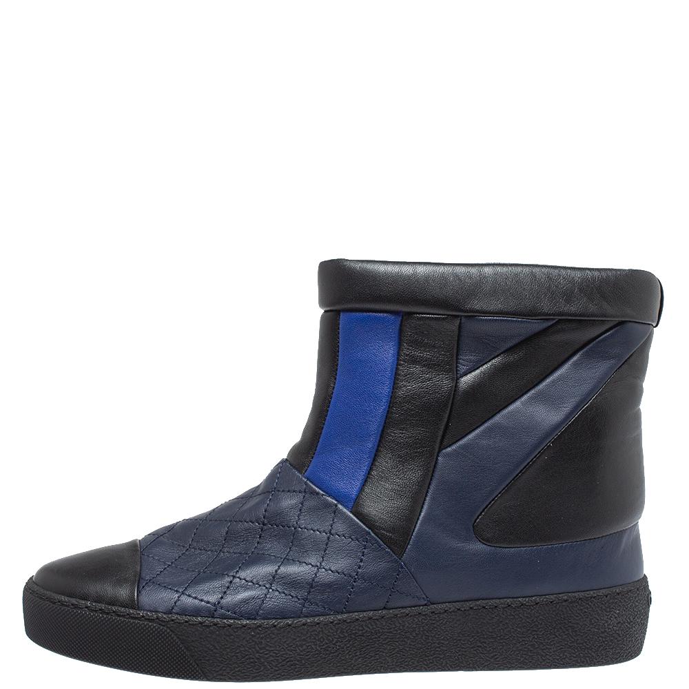 Step out and enjoy the snow wearing these boots from the house of Chanel. Crafted from leather in a combination of blue and black shades, they feature round toes and tough rubber soles. These boots are complete with an ankle-length