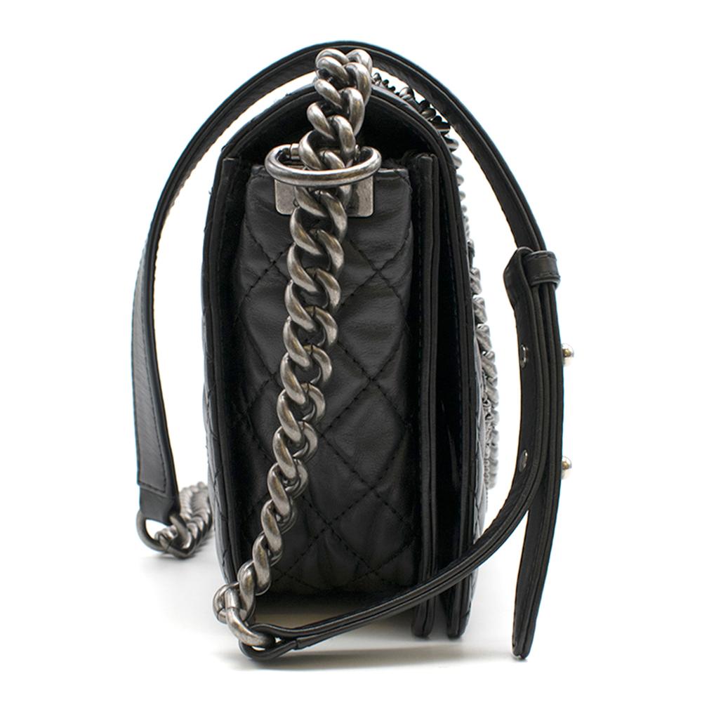 Chanel Black Caviar Leather Boy Bag with chain details. 

- Palladium hardware
- Chain details 
- Black grained leather body
- CC mademoiselle lock
- Chain strap can be worn on the shoulder or across the body
- Dust Bag Included 

Please note, these