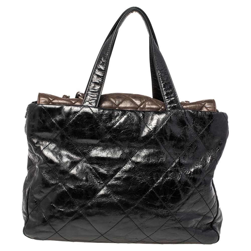 Chanel ‘Portobello’ tote is perfect for the daily commute. Crafted from black quilted iridescent leather and brown aged leather, it features double flat leather top handles and double chain and leather entwined shoulder straps. The flap top with CC