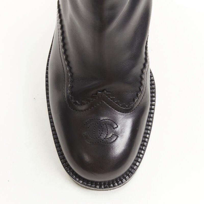 CHANEL black calfskin cross stitch cut out CC toe cap block heel boot EU38.5
Reference: KNLM/A00243
Brand: Chanel
Designer: Karl Lagerfeld
Material: Leather
Color: Black
Pattern: Solid
Closure: Zip
Lining:  Leather
Extra Details: CC logo at toe box.