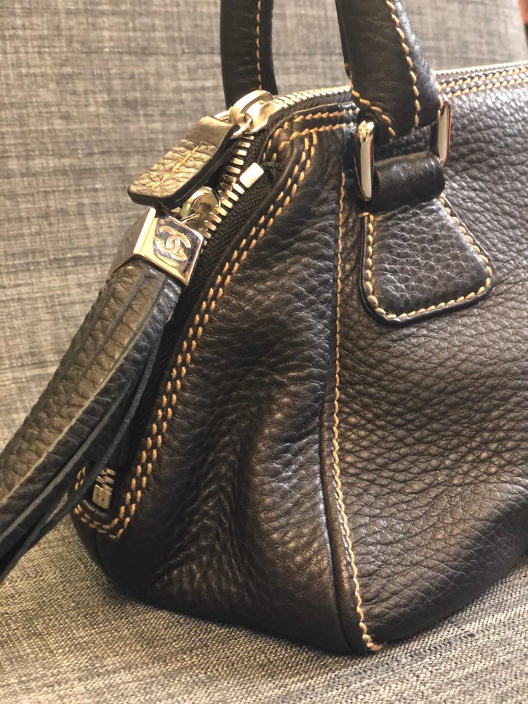 - Chanel black calfskin tassel handbag from 2003 to 2004 collection. 

- Silver Hardware zips closure. 

- Length: 34cm. 
  Height: 34cm.
  Width: 14cm. 
  Hand Drop: 20cm. 

