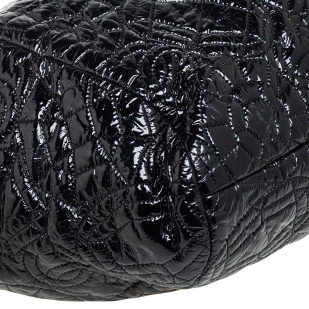 Diese wunderschöne Tasche von Chanel ist aus mit Kamelien geprägtem Lackleder gefertigt. Die Tasche verfügt über geflochtene Schultergriffe aus Kettenleder, ein CC-Logo auf der Vorderseite und eine Innenausstattung aus Satin, in der alle wichtigen