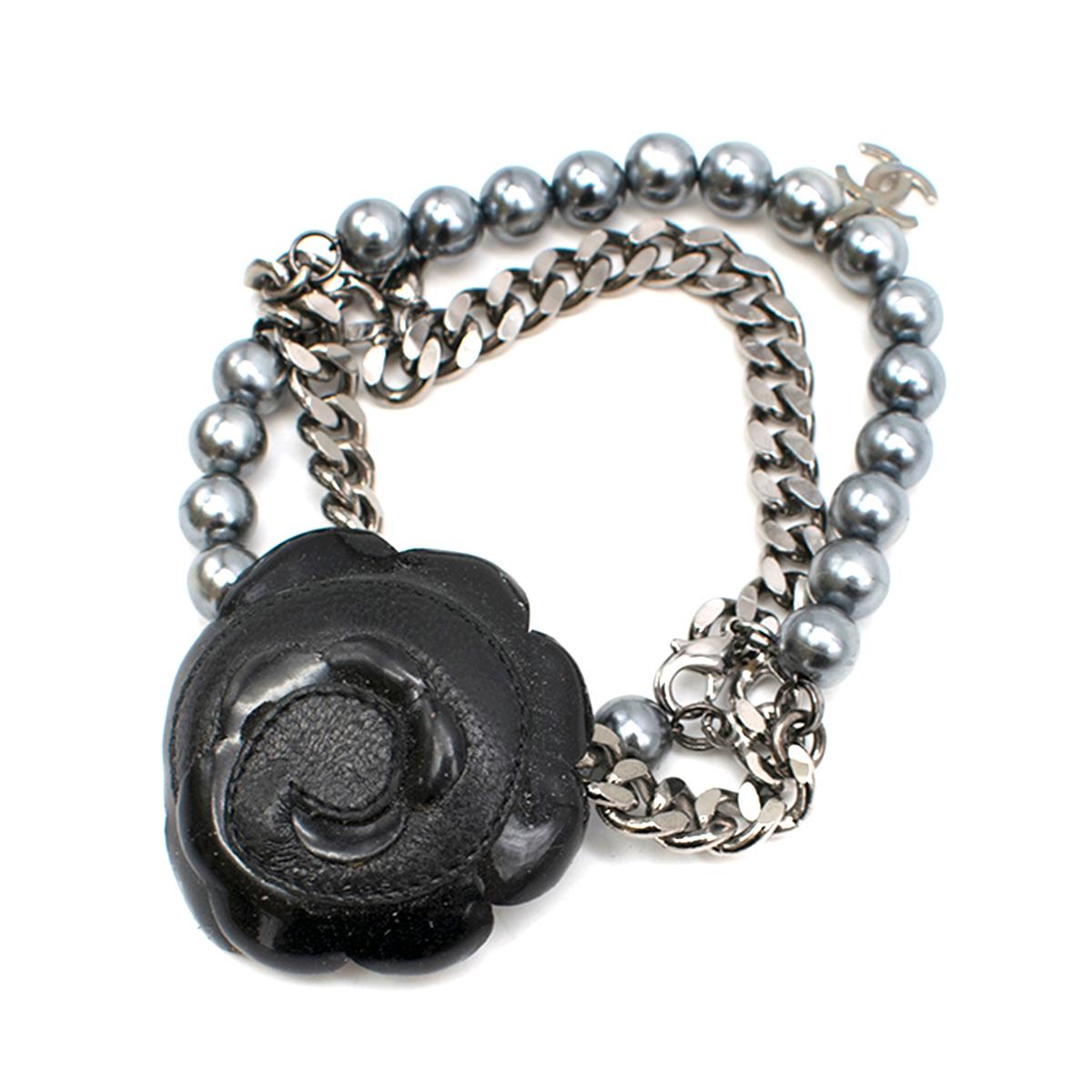 Chanel Black Camellia Faux Pearl & Chain Bracelet

- Double strap bracelet made of metal chain and faux pearls
- Chanel logo detail 
- Removable black leather camellia with the velcro fastener
- Bracelet does not have main clasp
- Small size

Please