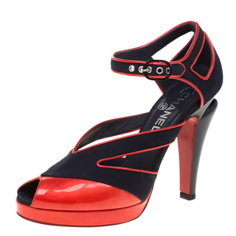 You'll enchant the crowds every time you step out in these gorgeous pumps from Chanel! These black pumps have been crafted from canvas and red patent leather and styled with peep-toes and cut-out detailed vamp straps. They flaunt the signature CC