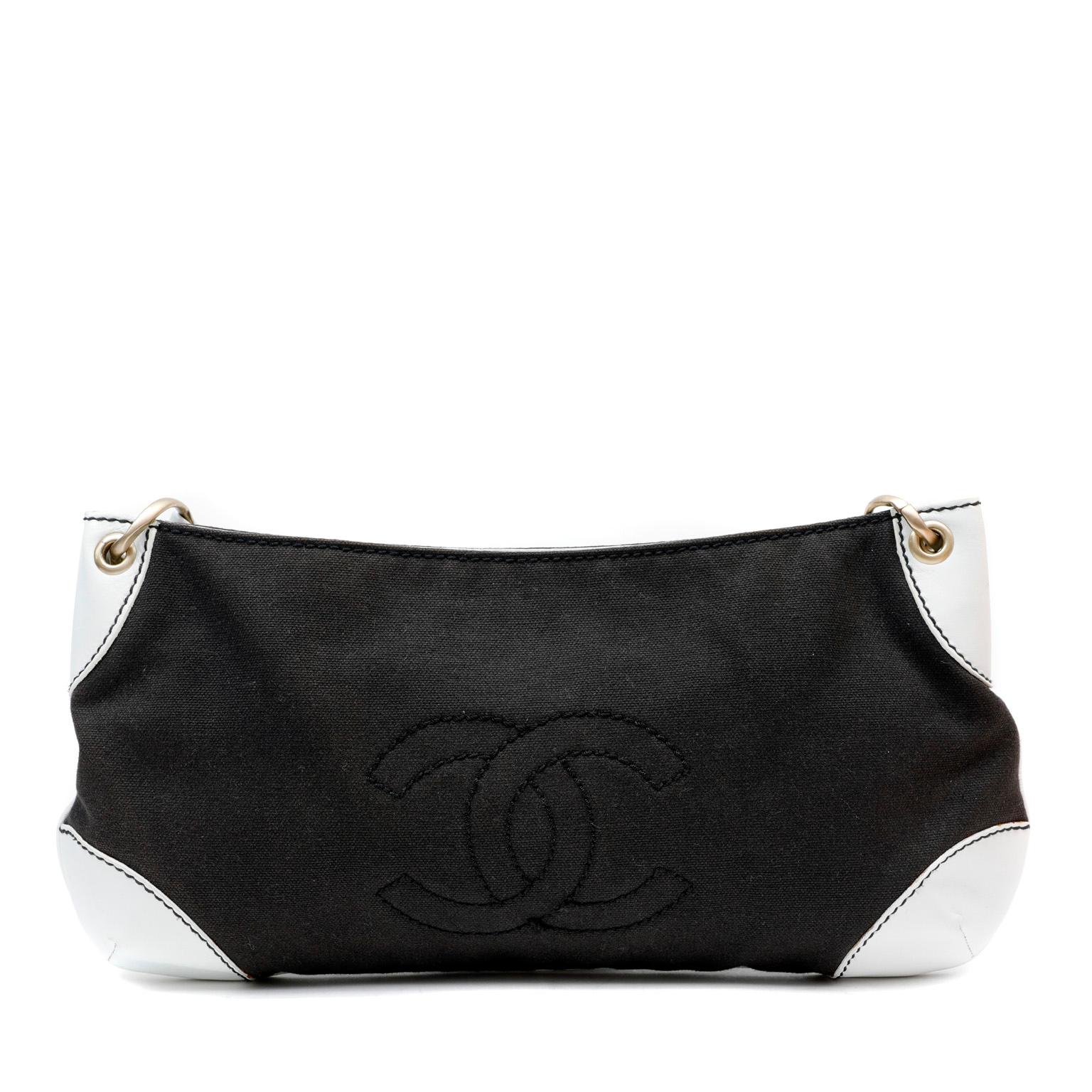 This authentic Chanel Black Canvas Shoulder Bag is in very good condition.  Black canvas with tonally stitched interlocking CC and white leather reinforced corners.  Substantial white leather single strap is interwoven with matte gold linked chain. 