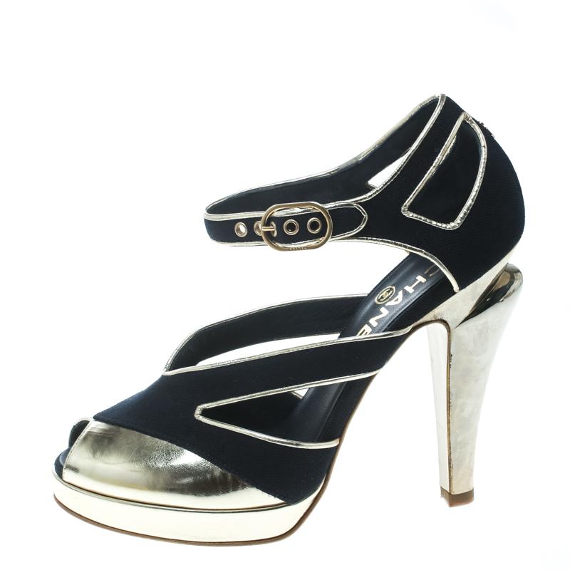You'll enchant the crowds every time you step out in these gorgeous pumps from Chanel! These black pumps have been crafted from canvas and metallic gold leather and styled with peep-toes and cut-out detailed vamp straps. They flaunt the signature CC