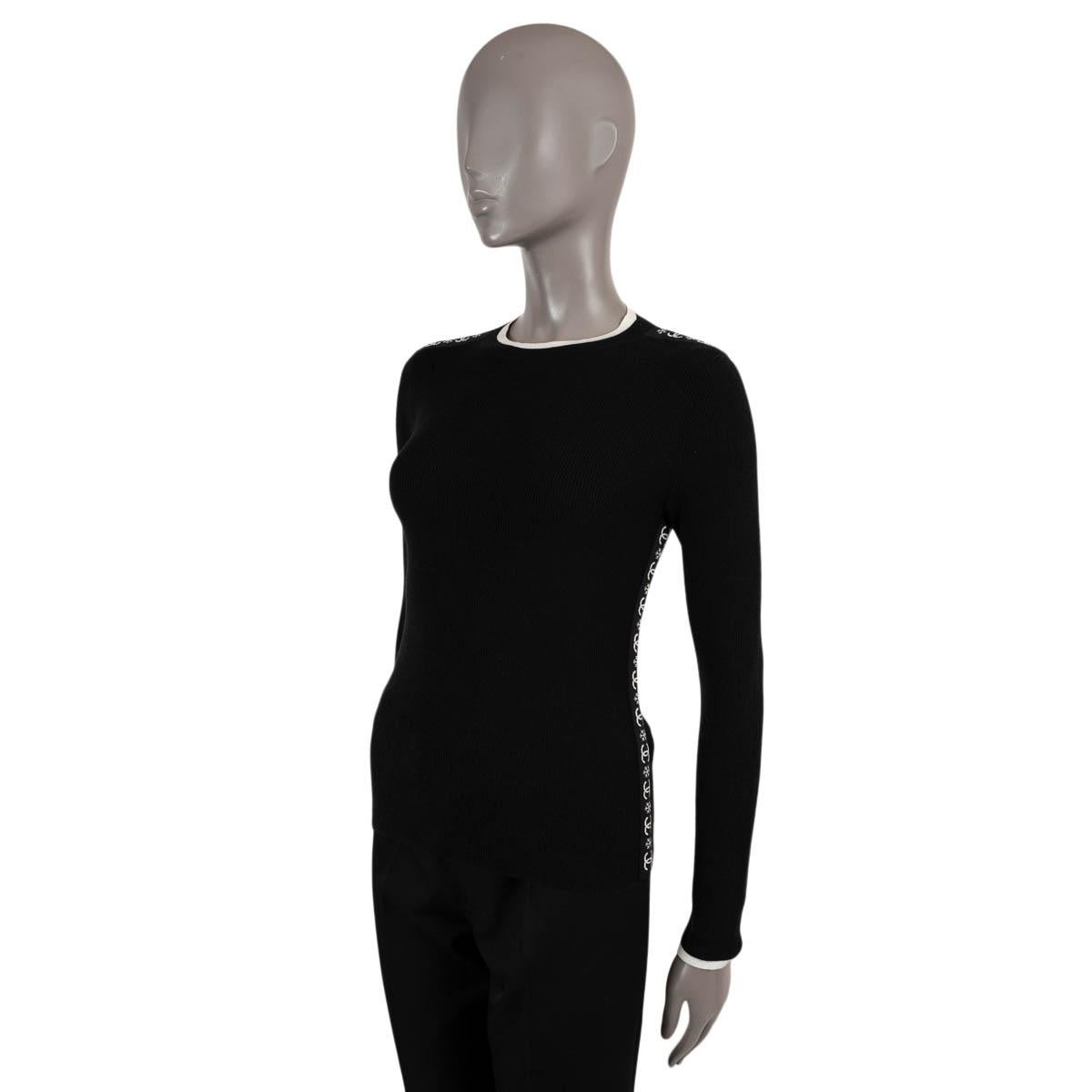 100% authentischer Chanel Pullover aus schwarzem Kaschmir (100%). Rundhalsausschnitt mit cremefarbenem Kontrastbesatz und cremefarbenen CC- und Schneeflocken-Schulter- und Seitenstreifen. Unbeschriftet. Wurde getragen und ist in ausgezeichnetem
