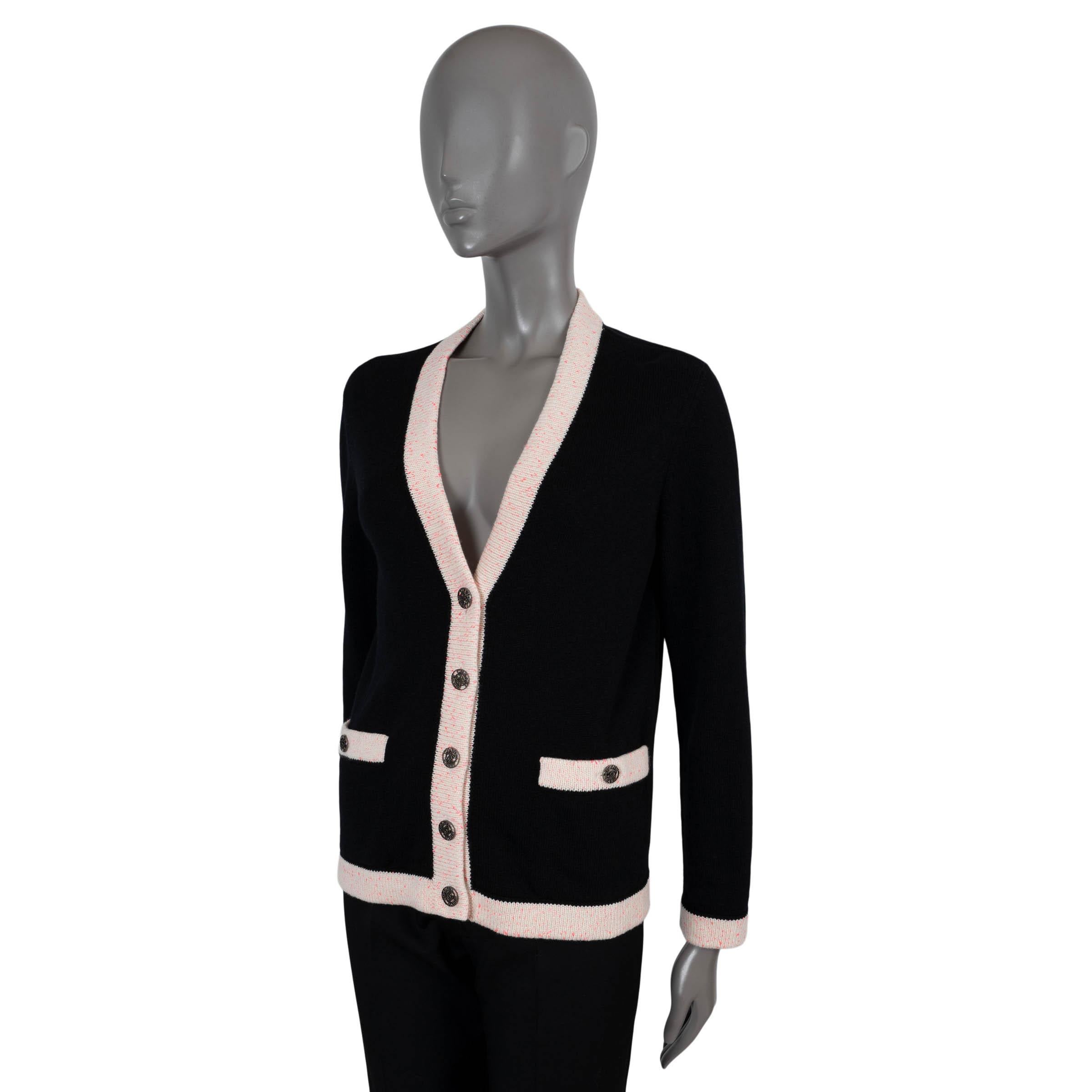 100% authentic Chanel cardigan in black cashmere (100%). Features a V-neck, with contrasting pink speckled cream rib-knit trims and two buttoned pockets at the waist. Closes with rhinestone encrusted metal logo buttons. Unlined. Has been worn and is