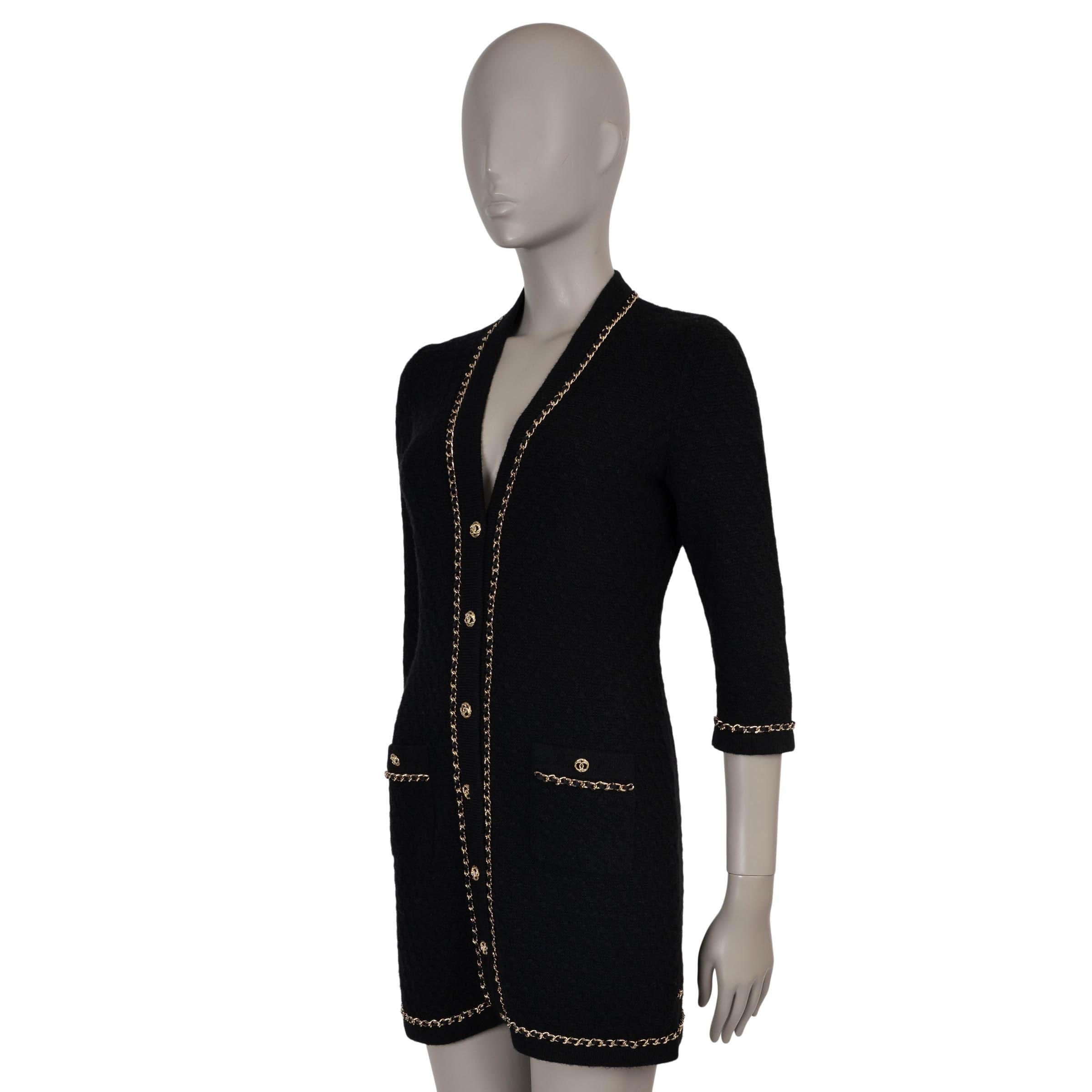 Cette robe cardigan en maille de cachemire texturée noire (100%), 100% authentique de Chanel, est une pièce raffinée et polyvalente, ornée d'une chaîne en métal doré. Conçue avec une silhouette ajustée et une longueur mini, elle présente une