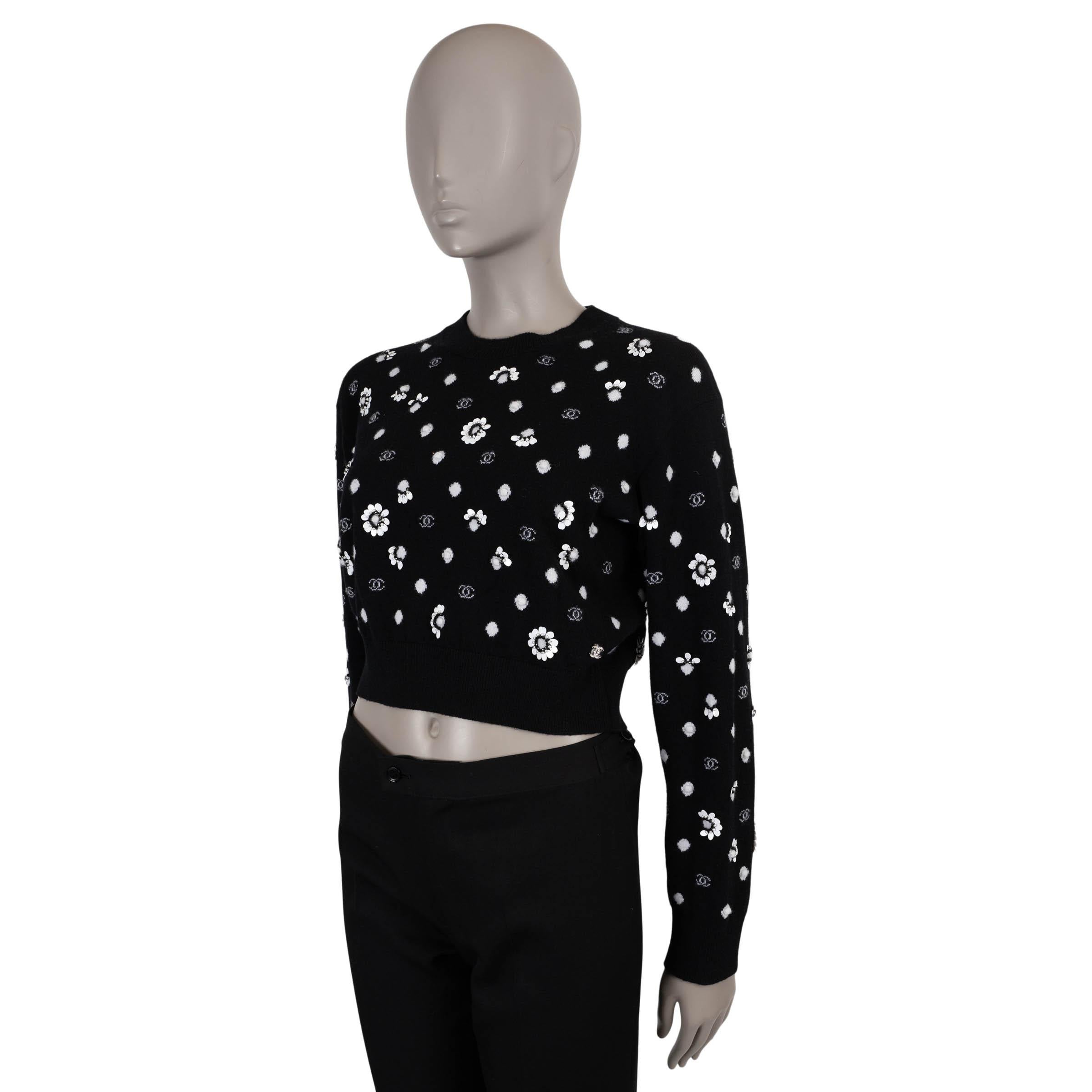 This 100% authentic Chanel sweater is a standout runway piece, exquisitely crafted in black cashmere (content and size tag missing). It features an all-over white CC and polka-dot jacquard, intricately embellished with couture-level floral appliqués