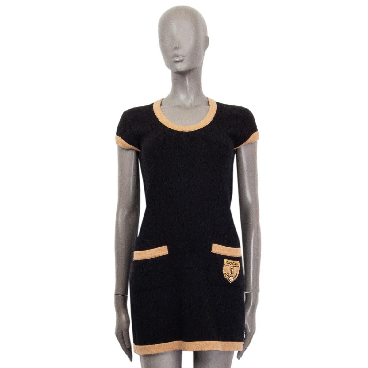 100% authentic Chanel knit mini dress in black cashmere (100%) with camel rib hems. Two front pockets with a beaded 'Coco Keyhole' patch. Has been worn wit a small hole on the first layer of cashmere on the neck. Can get repaired. Overall in very
