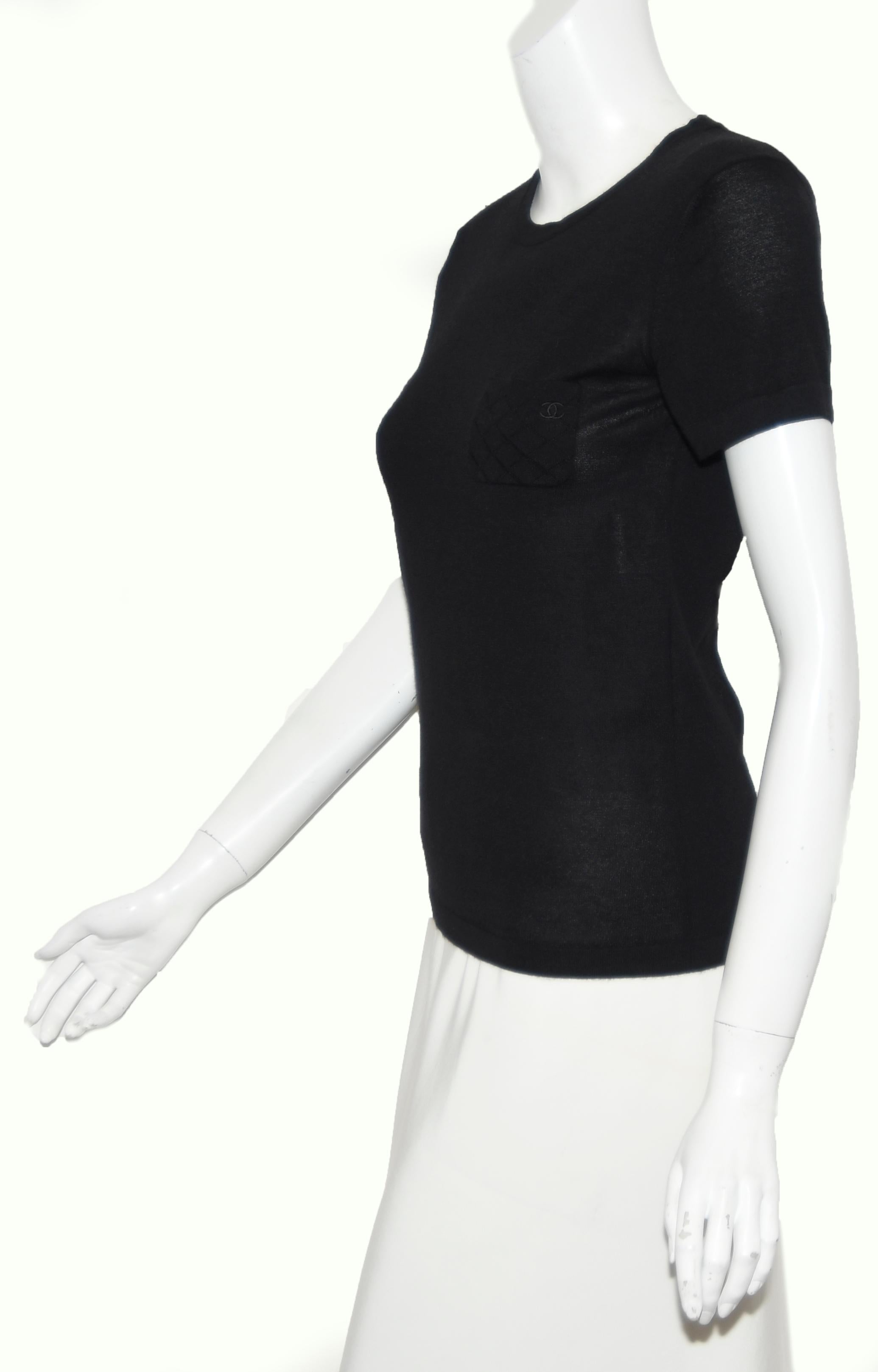Chanel black cashmere and silk short sleeve top and round neckline is not lined.  This Chanel T shirt has one small patch pocket on left side of chest that has the signature Chanel diamond print and CC embroidered logo.   The soft cashmere and silk
