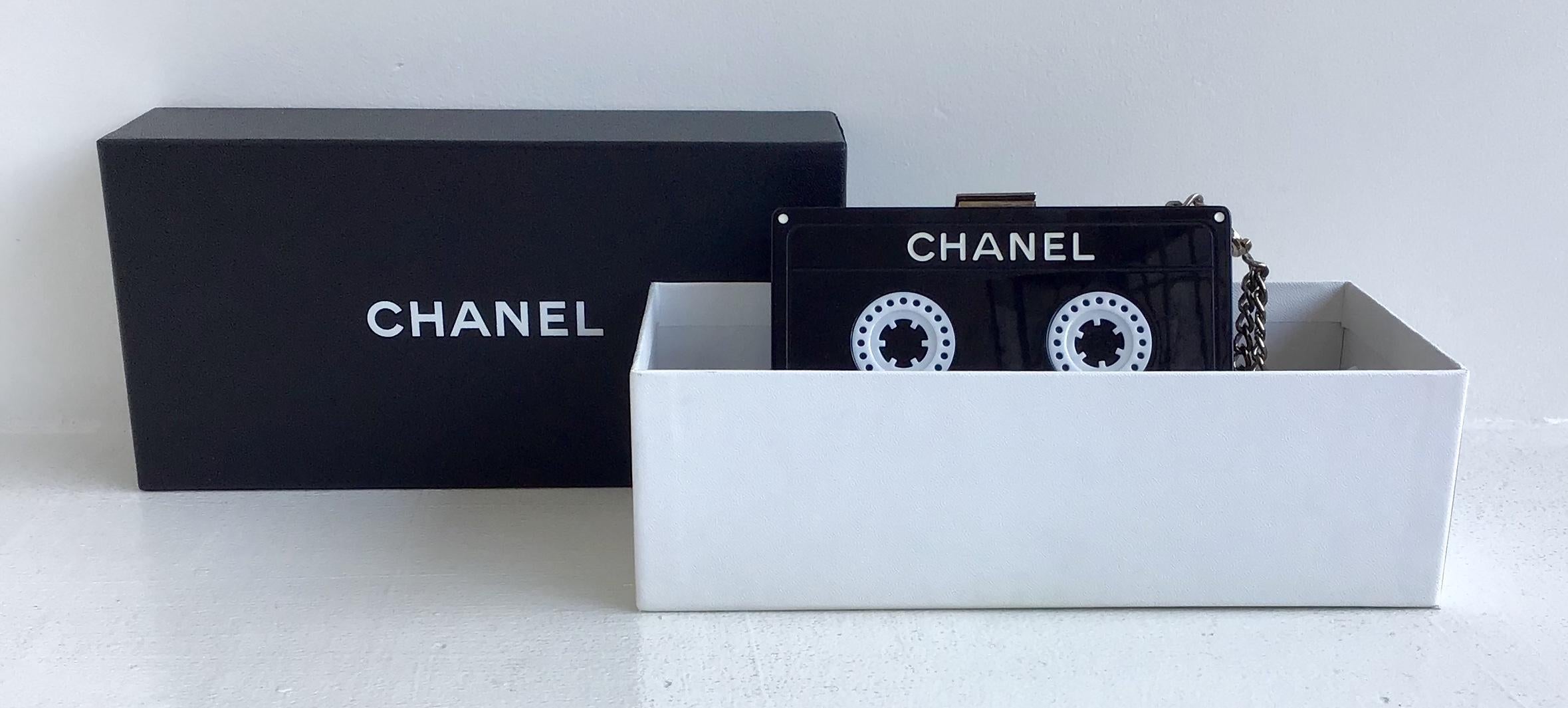Chanel Black Cassette Tape Clutch
Bag is rare. Black and white lucite hand-sized clutch with chain wristlet attached. 