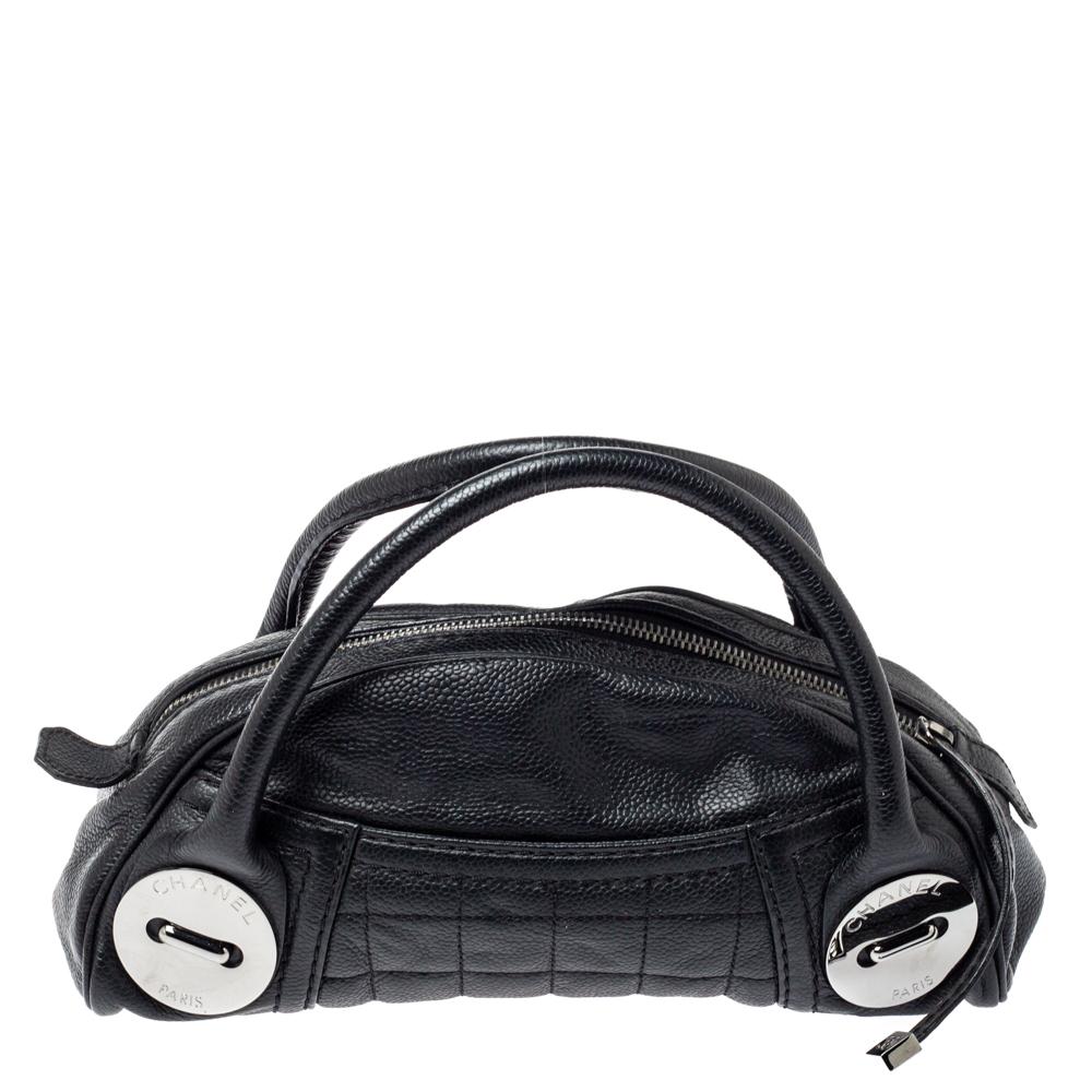 Stunning in appeal and high on style, this Chanel satchel has been crafted from caviar leather and styled with silver-tone hardware. It comes with dual top handles, engraved button details, protective metal studs at the bottom, and a top zip