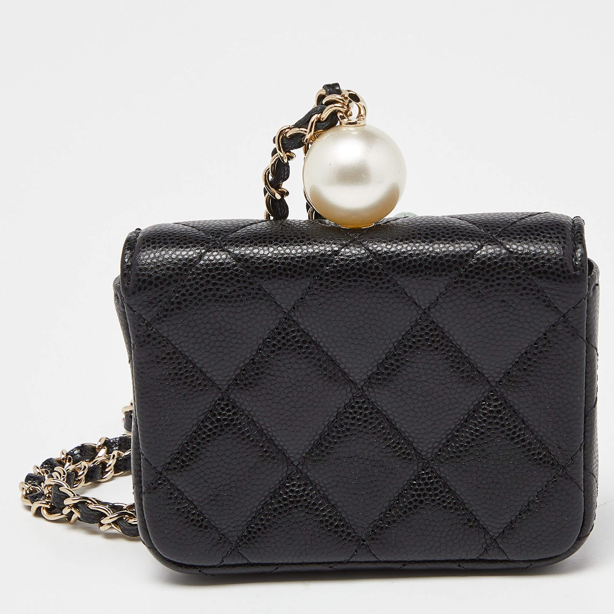 Constructed from black Caviar quilted leather, this coin purse with chain from Chanel is quite impressive! It features an exterior that is detailed with the signature quilted pattern and the iconic CC turn-lock logo in gold tone. It opens to compact