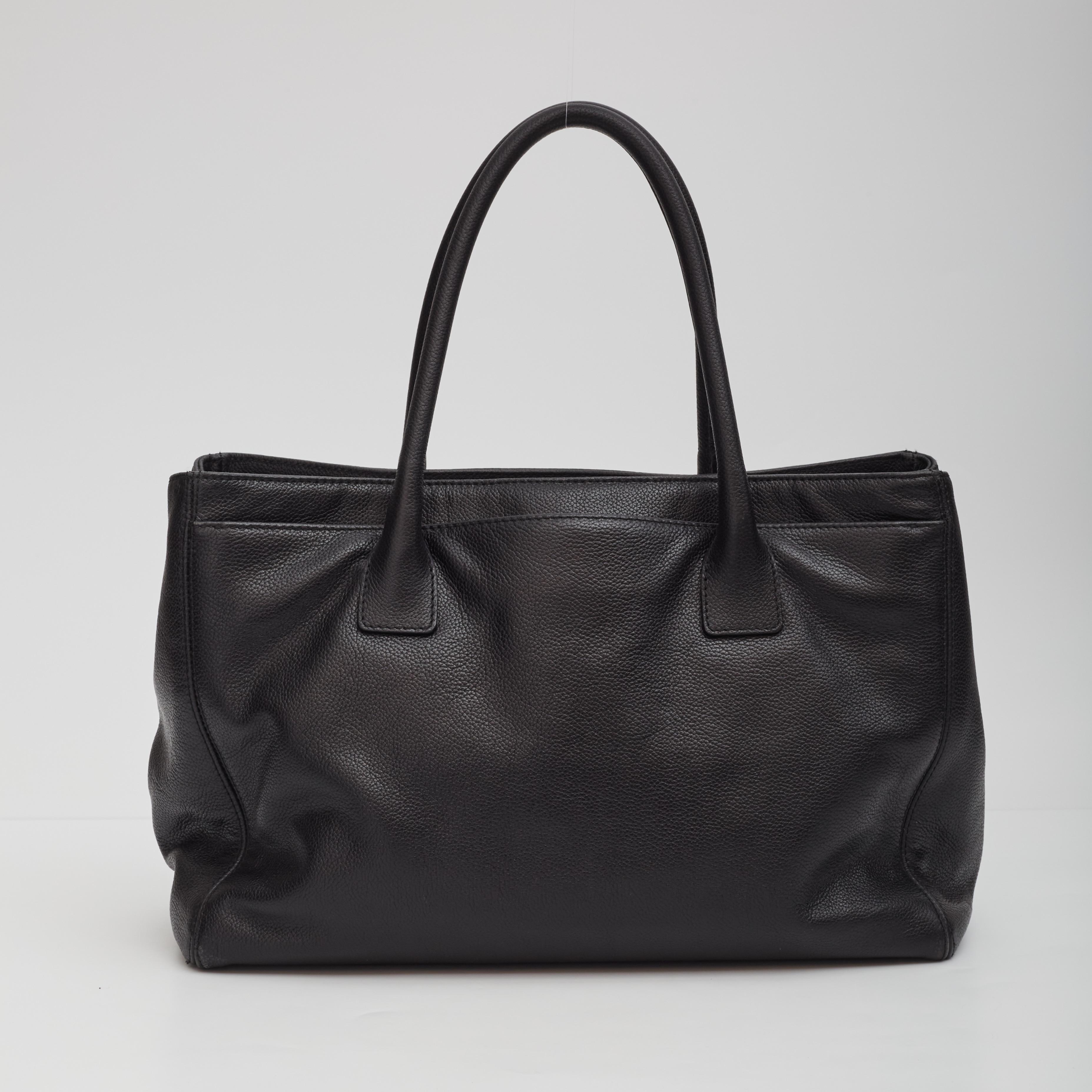 This vintage leather tote from the early 2000’s is made in black caviar leather. Featuring gold tone hardware, an open top with snap closure, front and back full length slip pockets, signature interlocking CC turn lock closure for the front slip