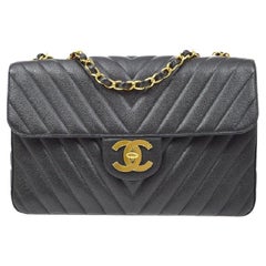 CHANEL Sac à bandoulière à rabat Maxi en cuir caviar noir à chevrons et accessoires dorés