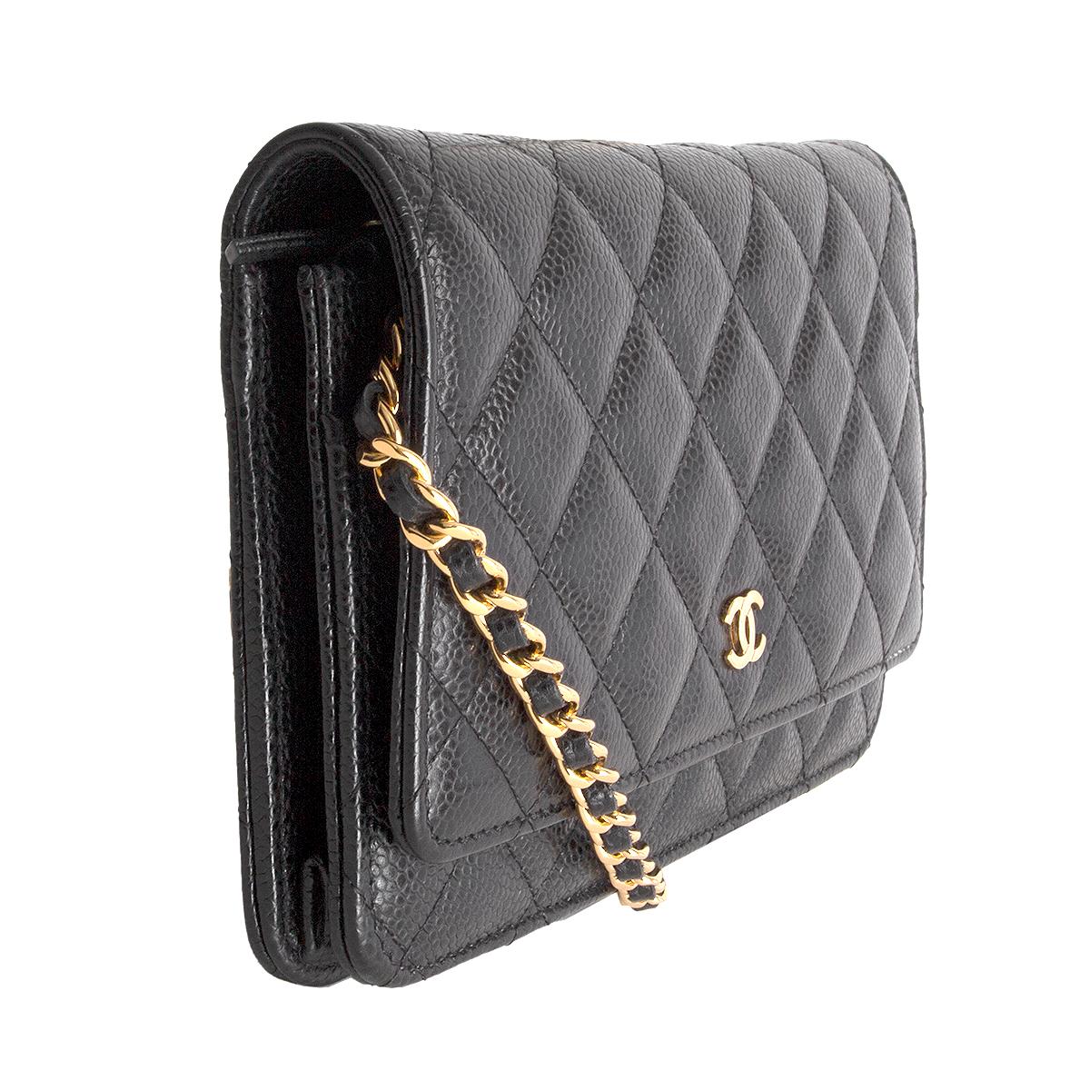 Chanel 'WOC' in black Cavair leather featuring gold-tone chain and ghardware. Opens with a push button to dark burgundy grosgrain interior with one slip pocket under the flap. Contains a zipper pocket against the front, one leather slip pocket and