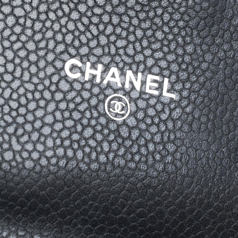 Carry your bills and cards in this Chanel wallet. The black Caviar leather exterior is accented with a silver-tone brand logo on the front flap which opens to a fabric-lined interior. The interior houses multiple card slots and a zipped